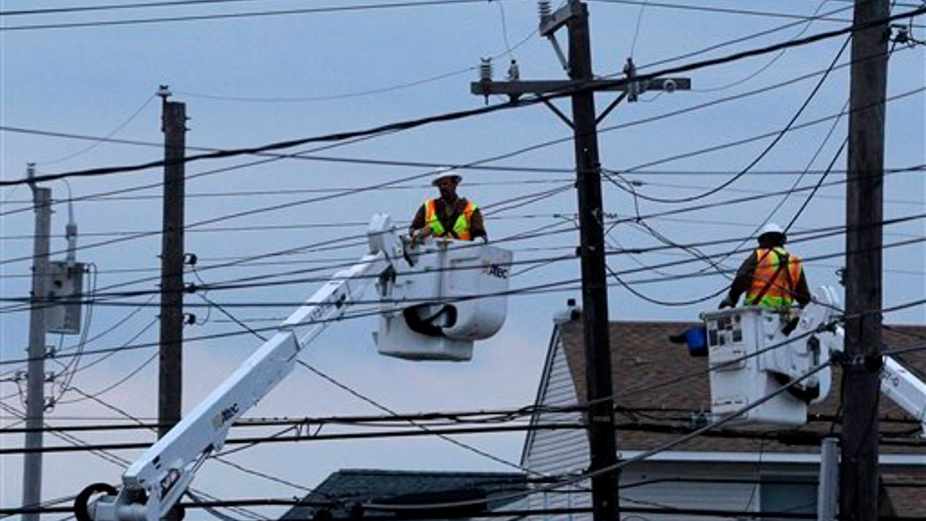 Utility crews work on power lines in response to superstorm Sandy as dusk falls in Ship Bottom, a community on Long Beach Island, N.J., Thursday, Nov. 1, 2012. Superstorm Sandy has left parts of New Jersey's beloved shore in tatters, sweeping away beaches, homes and amusement parks. The devastation leaves the state a blank canvas to redevelop. But environmentalists and shoreline planners are now urging the state to think about how and if to redevelop the shoreline. (AP Photo/Patrick Semansky)