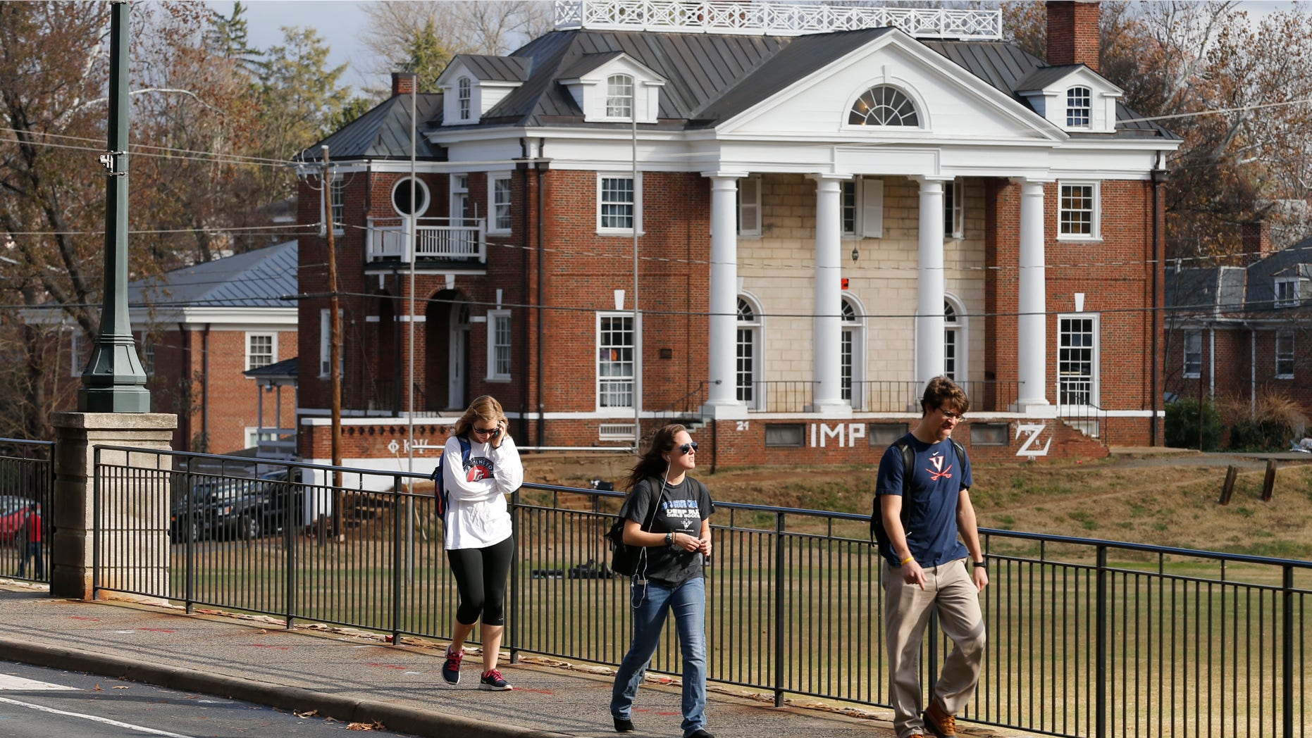 Nov. 24, 2014: University of Virginia students walk to campus past the Phi Kappa Psi fraternity house at the University of Virginia