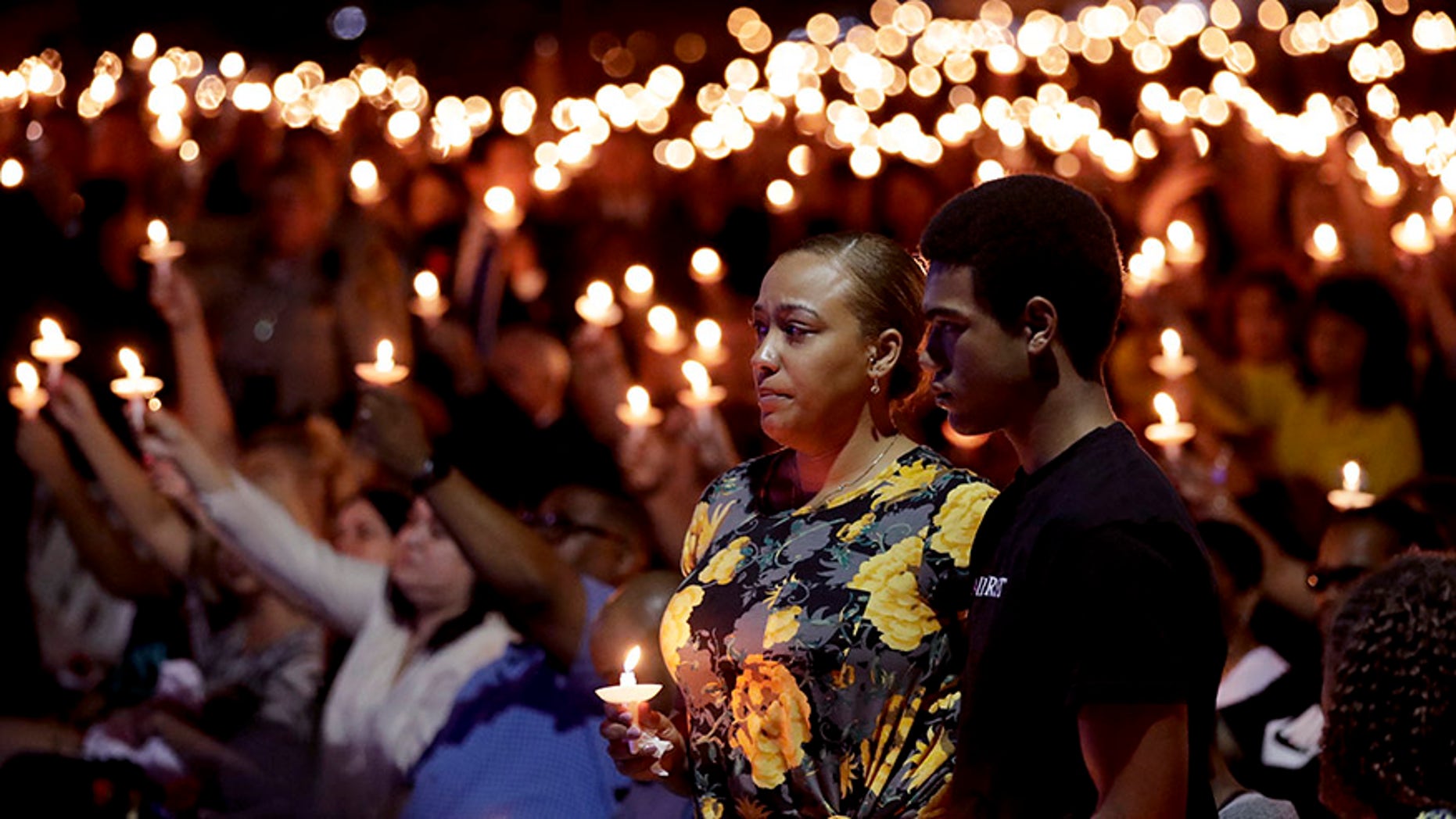 Oct. 5, 2017: Veronica Hartfield, stands with her son, Ayzayah Hartfield during a candlelight vigil for her husband, Las Vegas police officer Charleston Hartfield.