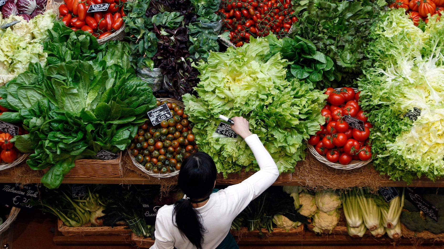 An employee arranges pricetags at a vegetables work bench during the opening day of upmarket Italian food hall chain Eataly's flagship store in downtown Milan, March 18, 2014. REUTERS/Alessandro Garofalo
