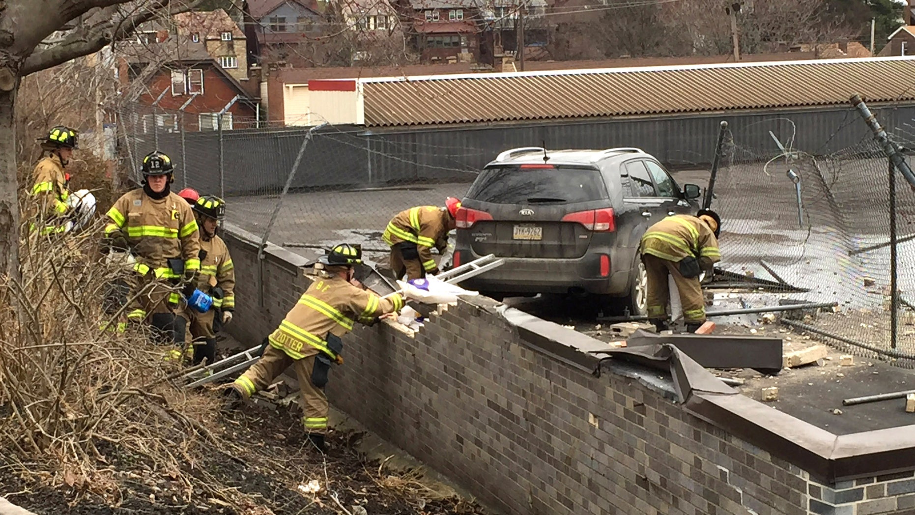 Emergency personnel check a vehicle that crashed onto the roof of a supermarket.