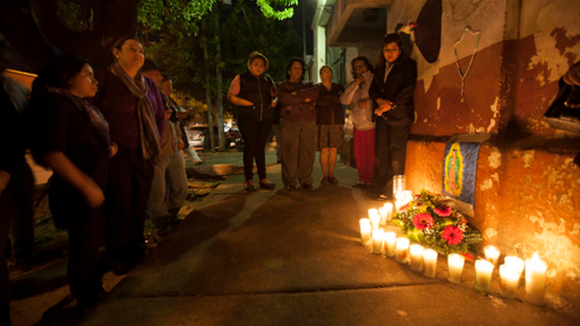 People hold a candlelight vigil in remembrance of the victims of a fire at a children's shelter, outside the morgue where the bodies are being identified in Guatemala City, Wednesday, March 8, 2017.