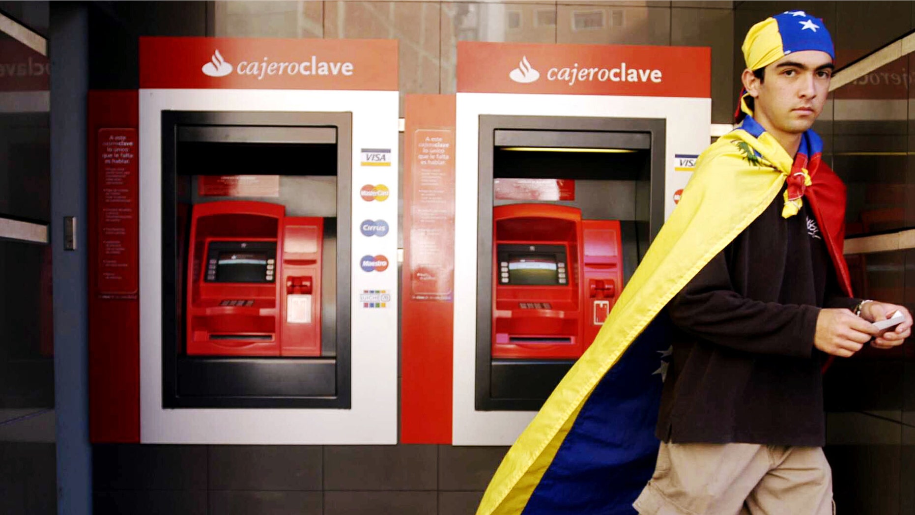 CARACAS, VENEZUELA - A Venezuelan resident walks away from an ATM at a bank on January 9, 2003 in Caracas, Venezuela. An official with the Venezuelan Bank Association said the strike forced 70 percent of bank branches nationwide to close due to the nation wide two-day bank strike. (Photo by Susana Gonzalez/Getty Images)