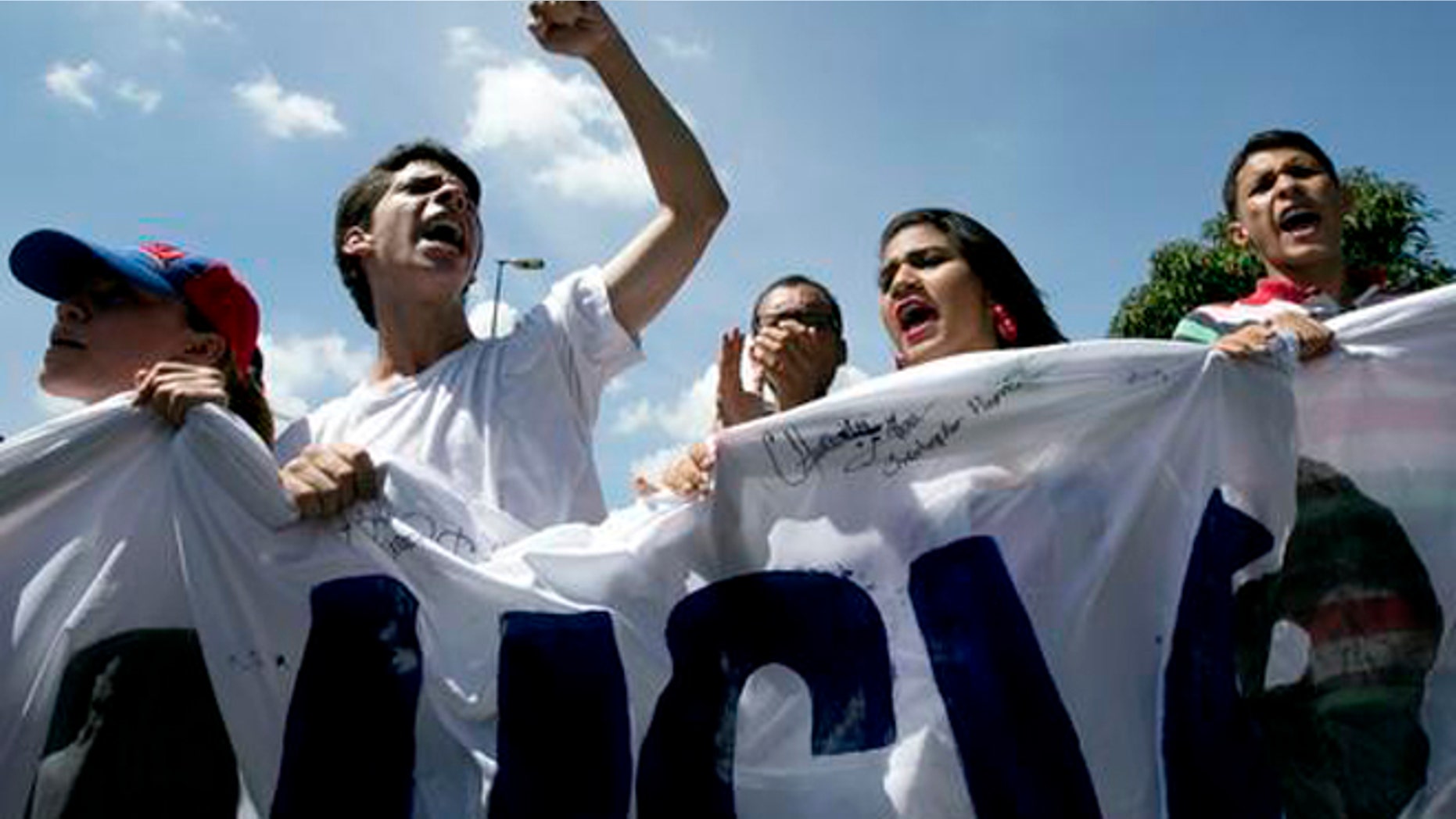 University students protest to demand a recall referendum against Venezuela's President Nicolas Maduro in Caracas, Venezuela, Friday, Oct. 21, 2016. Venezuela's electoral authority suspended a recall drive against Maduro on Thursday, less than a week before it was set to start, throwing the opposition's key campaign to oust the leader into further disarray. (AP Photo/Ariana Cubillos)