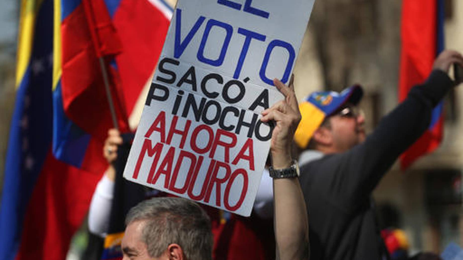 A Venezuelan living in Chile holds up a sign that reads in Spanish "The vote ousted Pinocho," referring to Chile's late dictator Gen. Augusto Pinochet, "Now Maduro," during a protest against the government of Venezuela's President Nicolas Maduro in Santiago, Chile, Saturday, Sept. 3, 2016. Protesters joined their countrymen in Venezuela who have coined recent protests as "taking of Caracas" to pressure electoral authorities to allow a recall referendum against Maduro this year. (AP Photo/Esteban Felix)