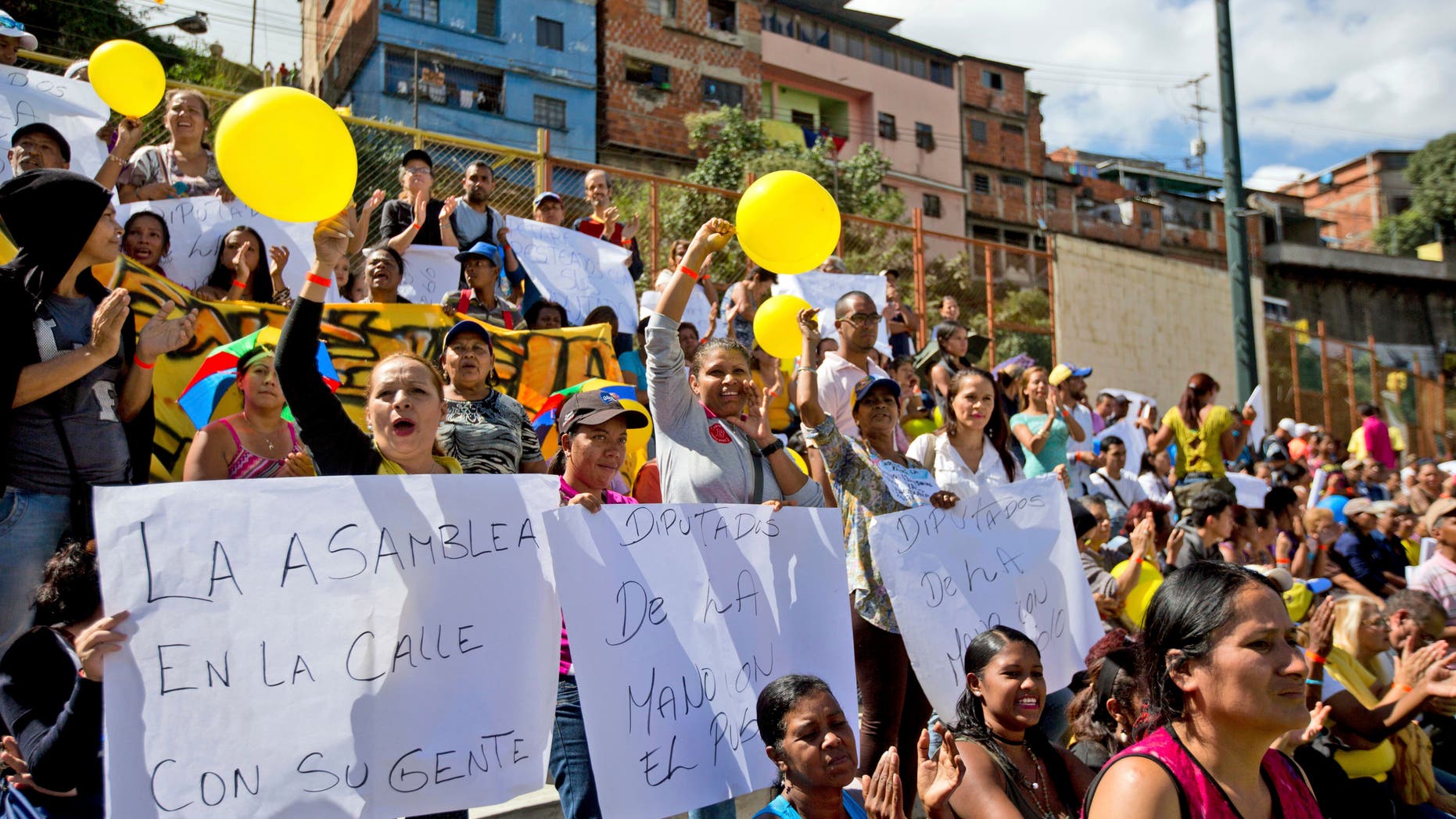 Caracas residents shout "Elections now!" during a session of the Venezuelan National Assembly at a sports park, Thursday, Jan. 26, 2017.