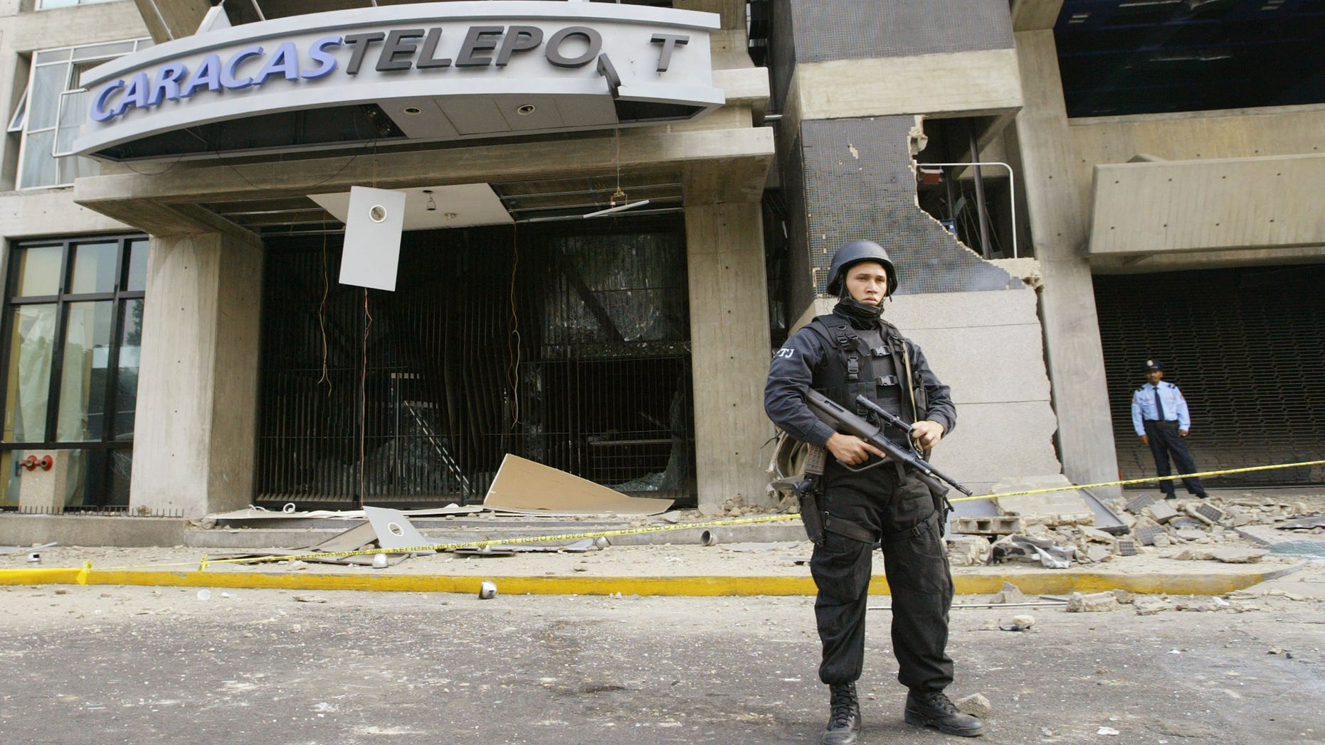 CARACAS, VENEZUELA - APRIL 12: A police man guards a building where a bomb exploded April 12, 2003 in Caracas, Venezuela. A bomb ripped through a building where government and opposition negotiators had agreed to hold a referendum on President Hugo Chavez. This blast follows several other bomb explosions in the last six weeks and falls on the year anniversary of a brief coup attempt against President Chavez. (Photo by Kimberly White/Getty Images)