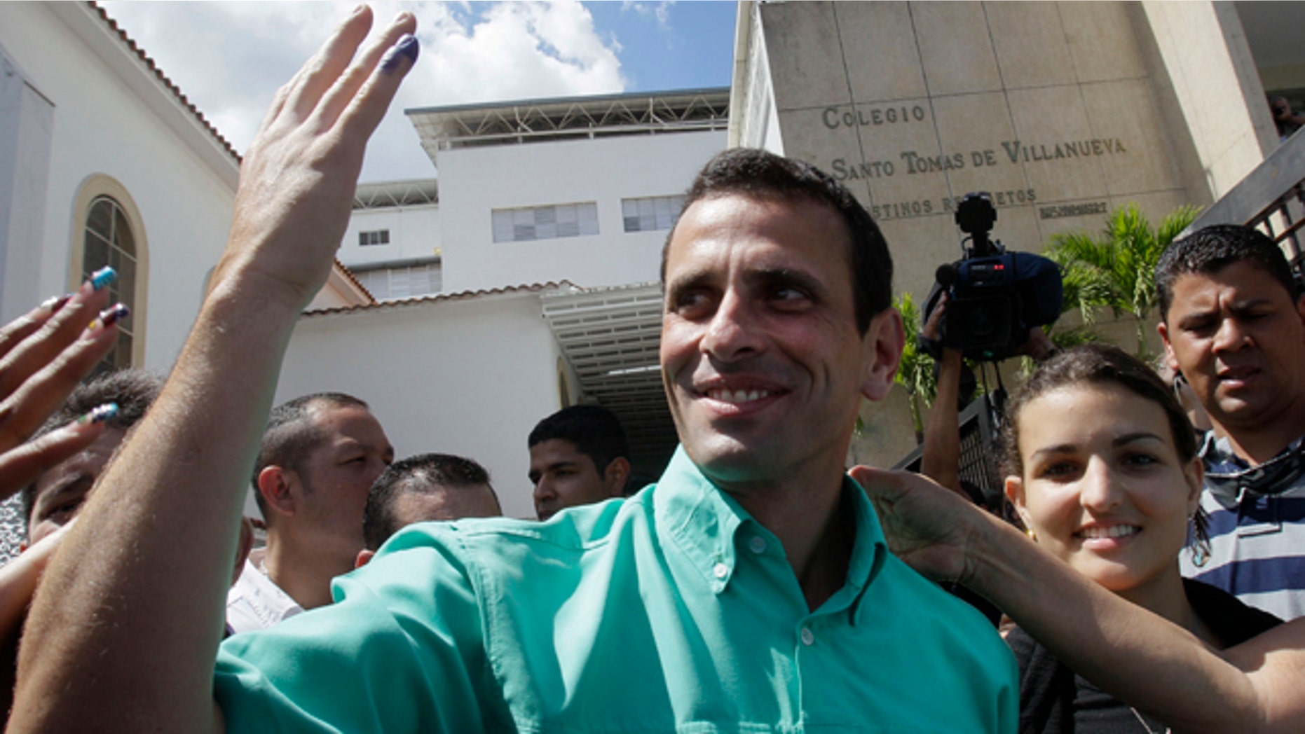 Feb. 12, 2012: Henrique Capriles, the front-runner among five opposition presidential contenders, shows off his ink-stained pinky as he leaves a polling station in Caracas, Venezuela.