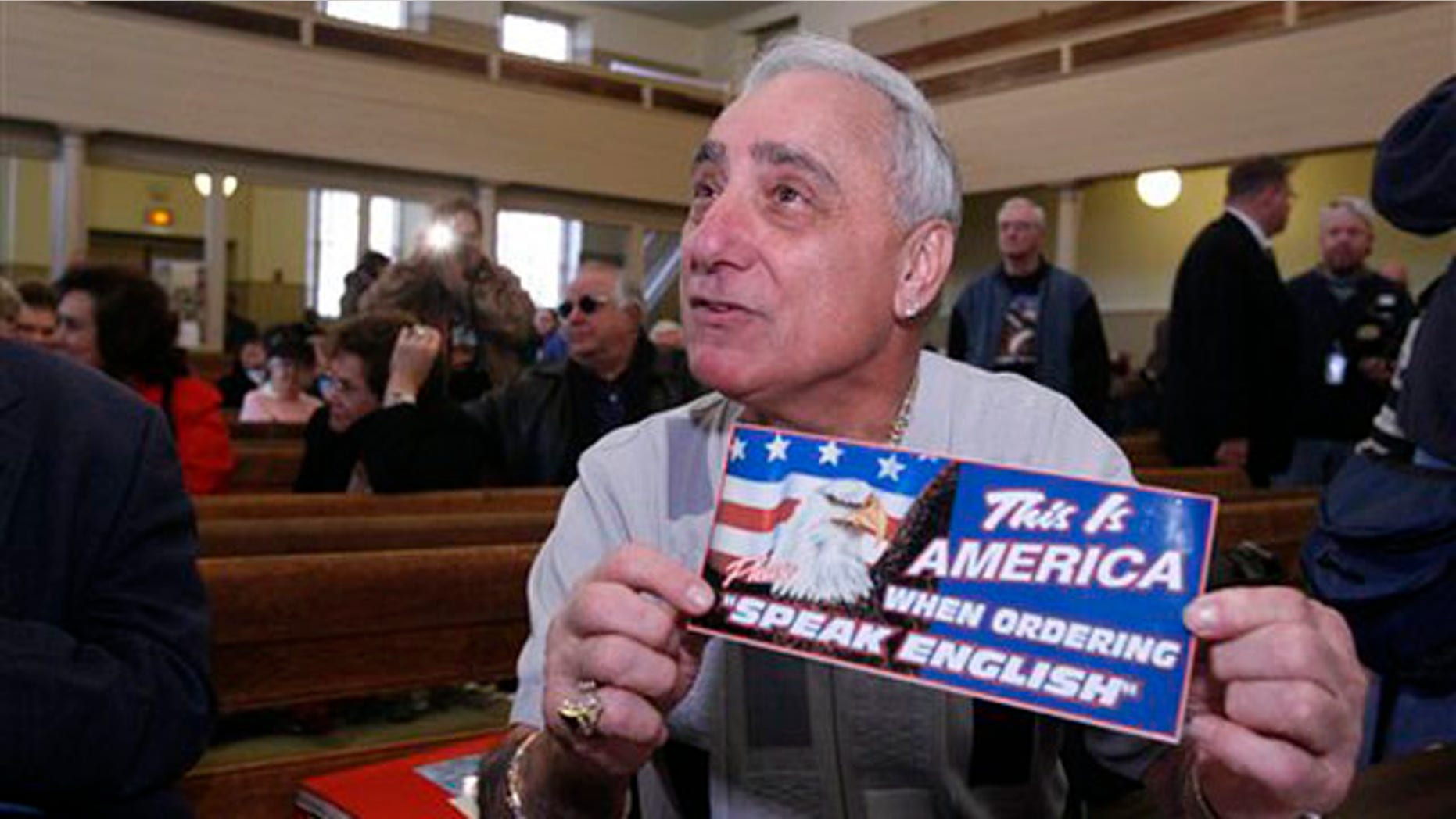In this Dec. 14, 2007 file photo, Joey Vento, owner of Geno's Steaks, displays a sign during a recess of a Commission on Human Relations hearing in Philadelphia.