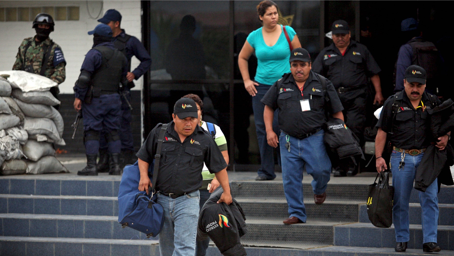 Municipal policemen leave a police station after the entire police force was disbanded in the Gulf port city of Veracruz, Mexico, Wednesday Dec. 21, 2011. The Veracruz state government said the decision is part of an effort to root out police corruption and start from zero in the state's largest city. The navy will be in charge of patrolling the city for the time being. (AP Photo/Felix Marquez)