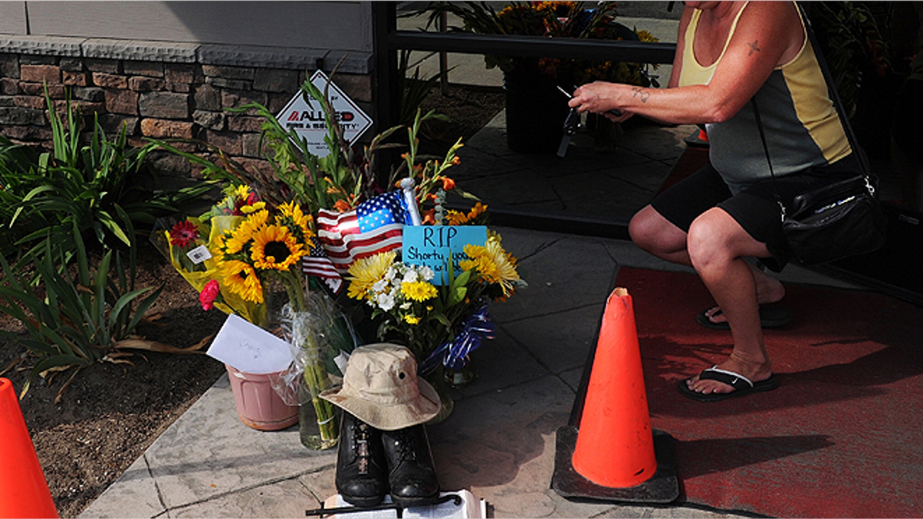 Aug. 22, 2013: Lill Duncan takes a photo of a memorial for Delbert Belton, an 88-year-old World War II veteran who was beaten to death, in Spokane, Wash. Police have arrested one of two teens suspected of fatally beating Belton, who had survived the battle for Okinawa, and the police chief said Friday, Aug. 23, that the brutal attack does not appear to have been racially motivated. (AP/The Spokesman-Review, Tyler Tjomsland)