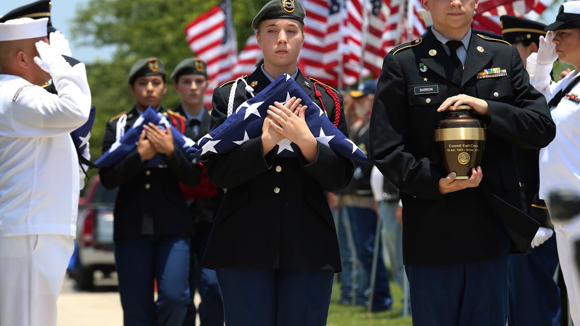 In this Friday, June 1, 2018 photo, MacArthur Junior ROTC students Michael Barron, right, and Grace Conger carry the cremated remains of veteran Everett Earl Criss as Fort Sam Houston National Cemetery and the Missing In America Project conduct a military burial service for the cremated remains of eight unclaimed veterans in San Antonio, Texas.