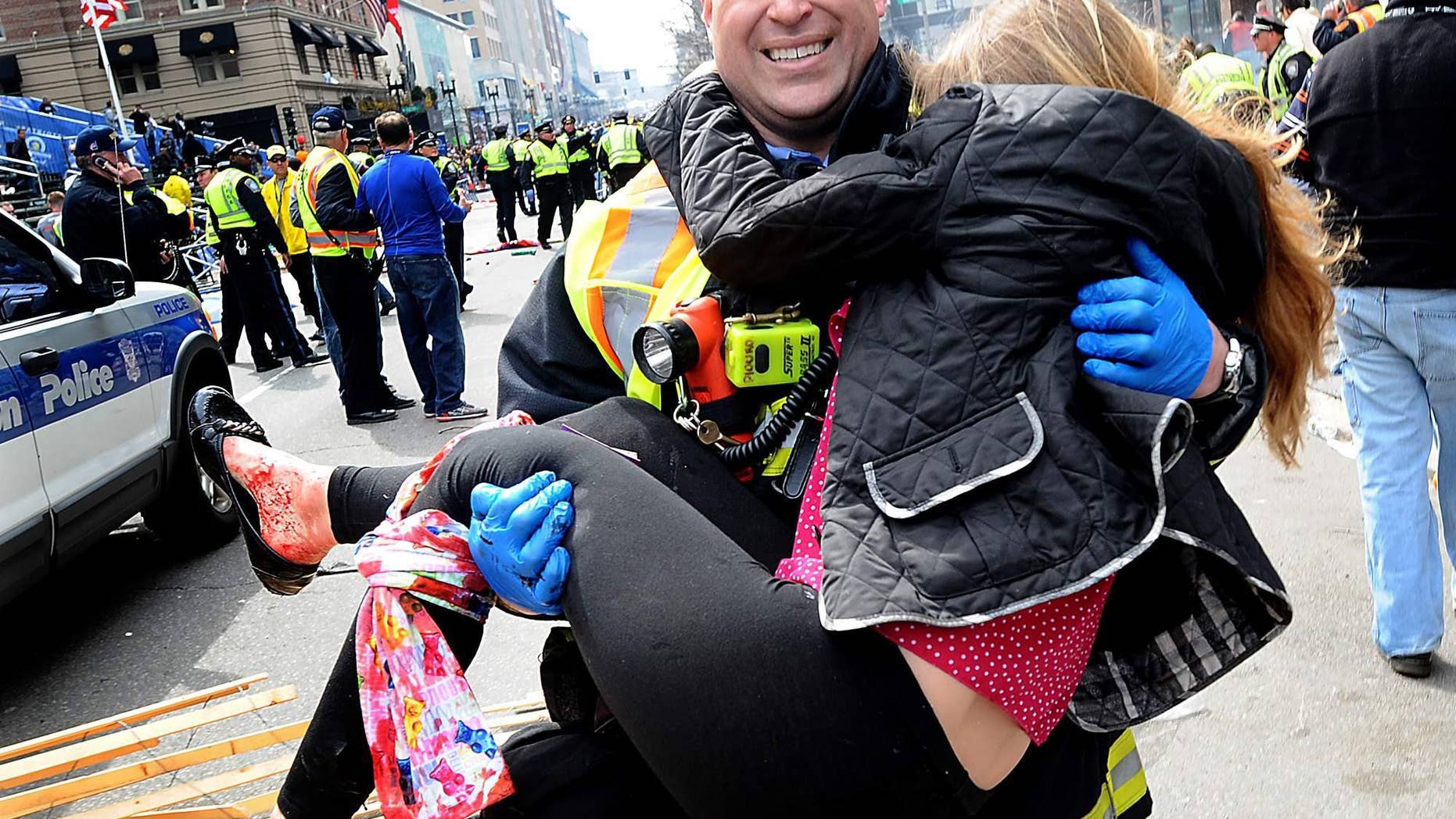 Victoria McGrath is carried in the arms of a firefighter after the Boston Marathon bombing.