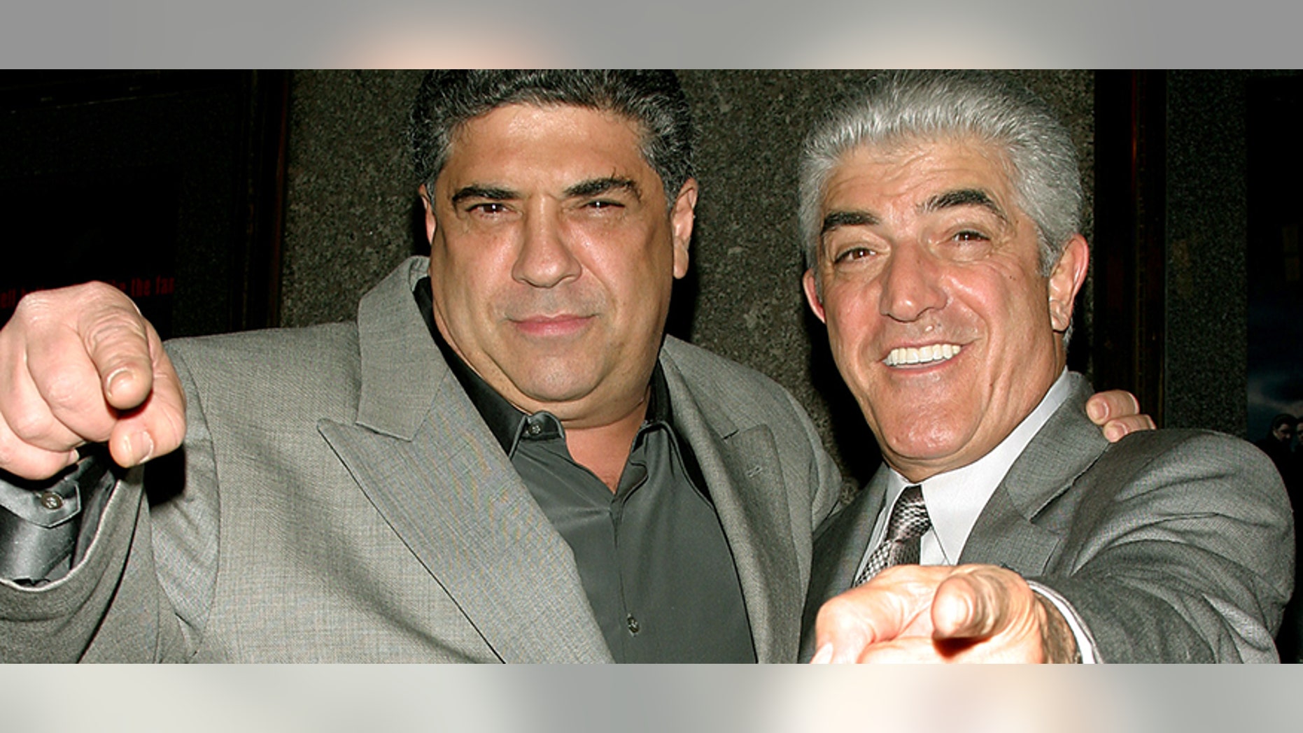 Actors Vincent Pastore (L) and Frank Vincent point at the photographers as they arrive for the fifth season premiere of the HBO series "The Sopranos," in New York March 2, 2004. - PBEAHUOKKBB