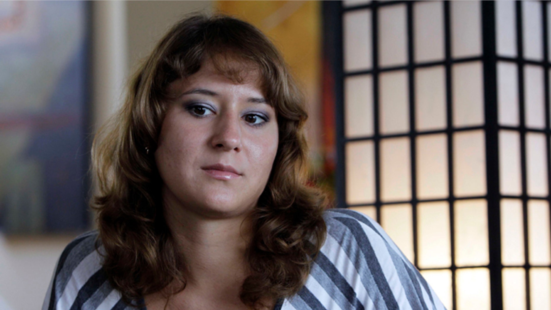 Aug. 24, 2010: Iuliia Bolgaryna sits for an interview in Surf City, N.C. Bolgaryna came to work on a J-1 visa at a souvenir store in Surf City, N.C. The store manager offered to let her and two other women from the Ukraine stay with him for $120 a week. But he wouldn't let them eat at the table, so they huddled together for meals on the floor. They worked loads of overtime but were only paid for 40 hours a week. (AP)