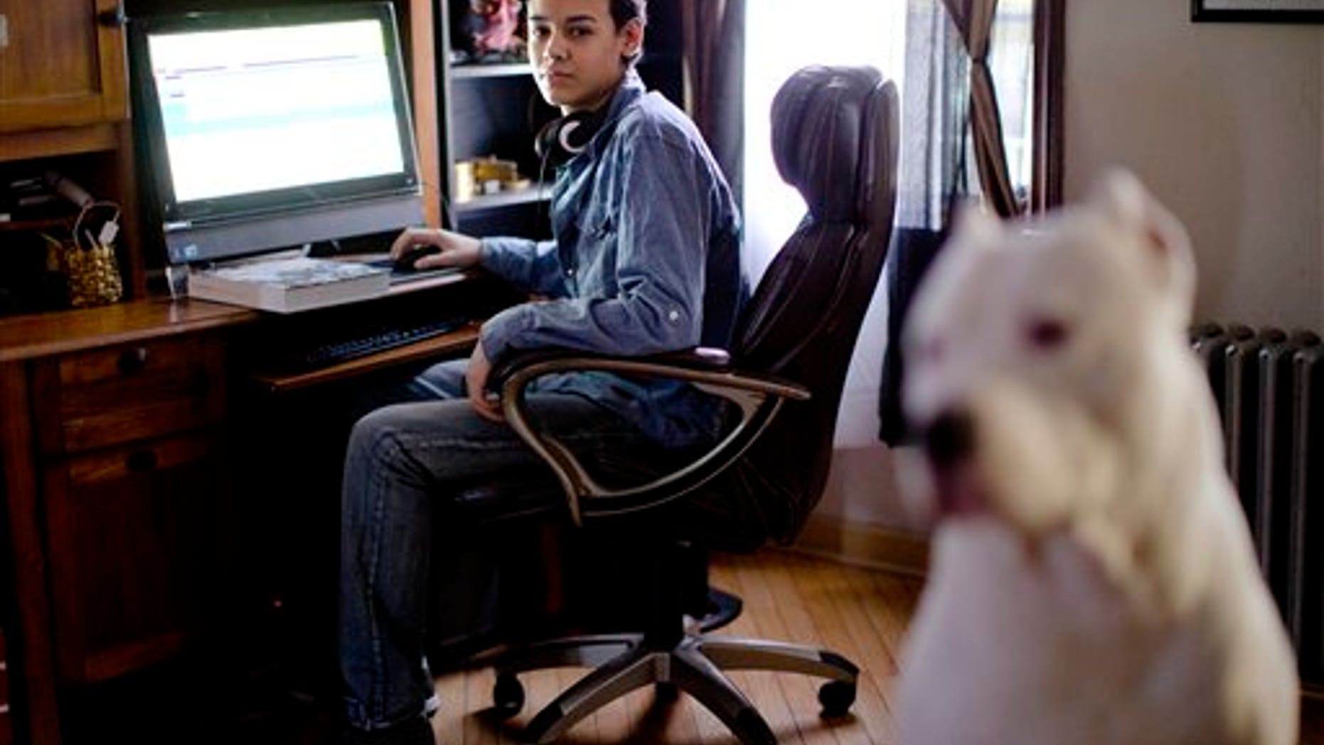 High school student Vito Calli, 15, poses for a portrait by his computer, Wednesday, Nov. 20, 2013, at his home in Reading, Pa. In a shift in attitude, most young people now say it's wrong to use racist or sexist slurs online, even if you're just kidding. But when they see them, they don't take much personal offense. Calli, whose family emigrated from Argentina, says people tease him online with jokes about Hispanics, but "you can't let those things get to you." (AP Photo/Matt Rourke)