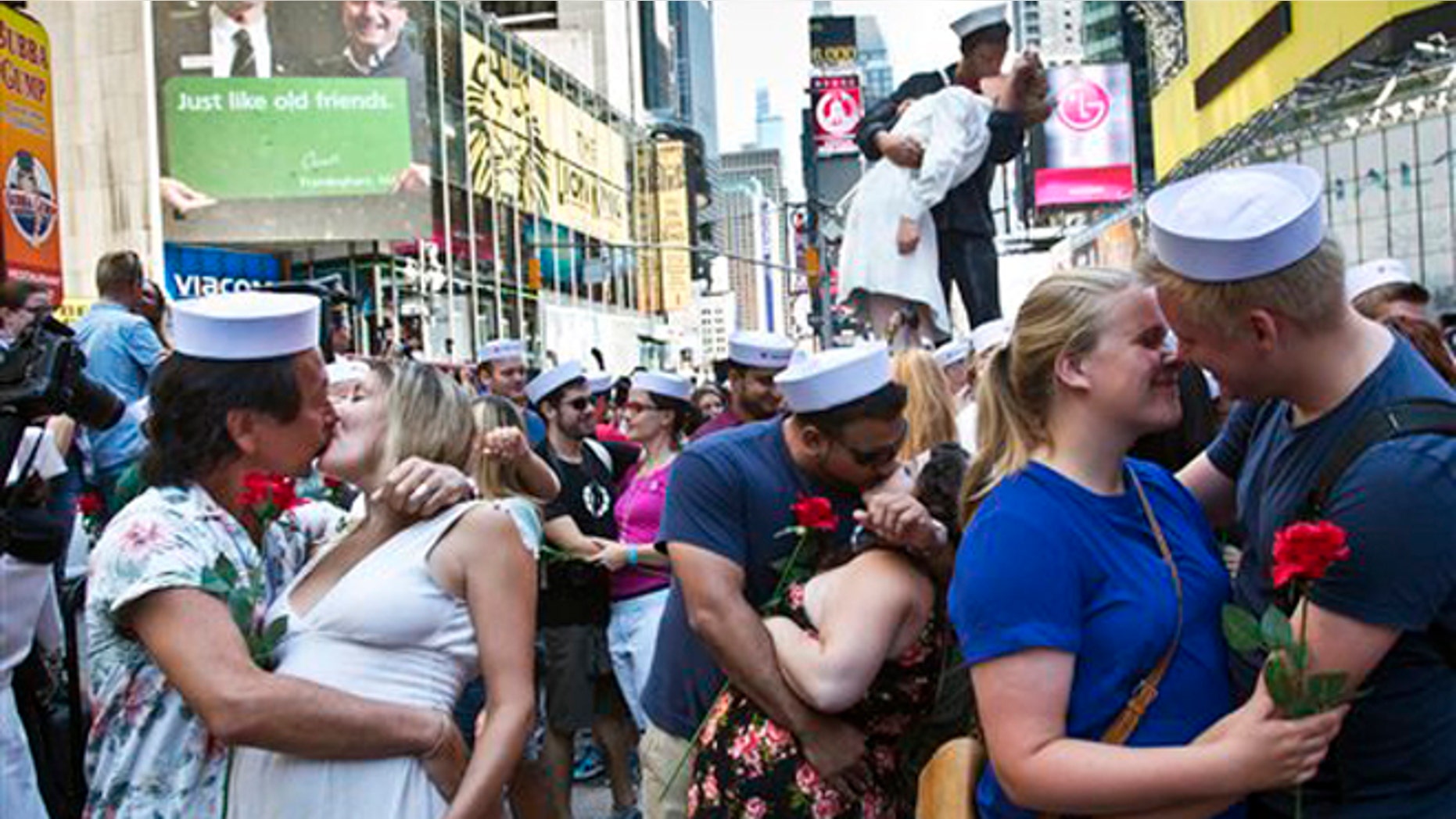 Friday Aug.14, 2015L Married couple Kenji and Kristen Kawasaki, far left, join others as they re-enact the iconic 1945 Alfred Eisenstaedt kiss photo in New York's Times Square. Dozens of couples gathered to re-enact the famous kiss that celebrated the end of World War II.