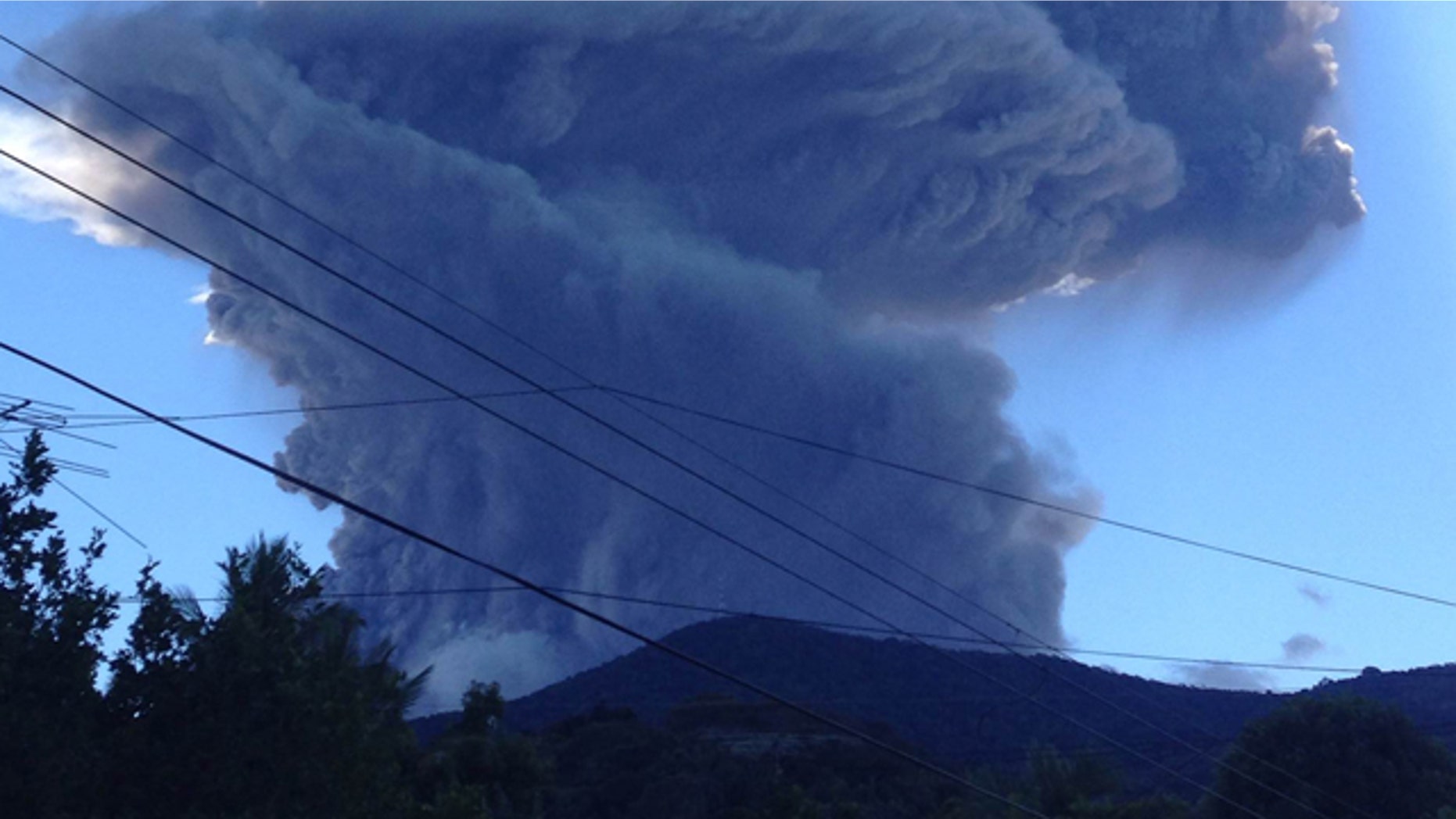 Dec. 30, 2013: The Chaparrastique volcano shoots a a cloud of gas and ash about three miles into the air as seen from the city of San Miguel, El Salvador.