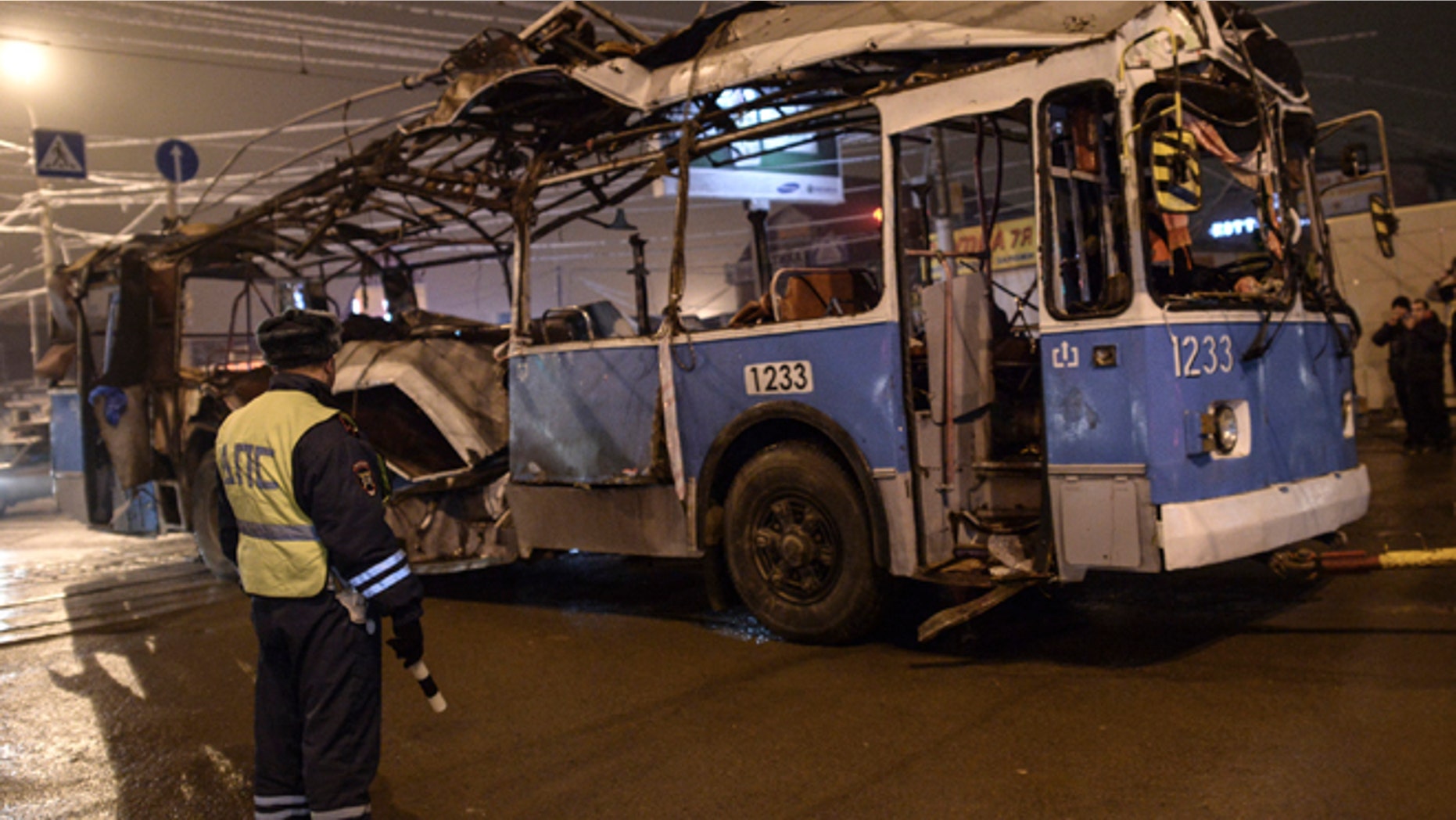 Dec. 30, 2013: A policeman watches as a bus, destroyed in an earlier explosion, is towed away in Volgograd.