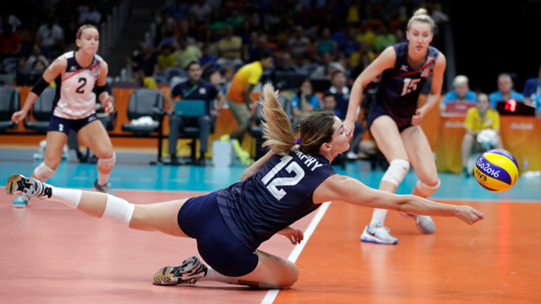 United States' Kelly Murphy (12) dives for the ball as teammates Kayla Banwarth (2) and Kim Hill watch during a women's quarterfinal volleyball match against Japan at the 2016 Summer Olympics in Rio de Janeiro, Brazil, Tuesday, Aug. 16, 2016.