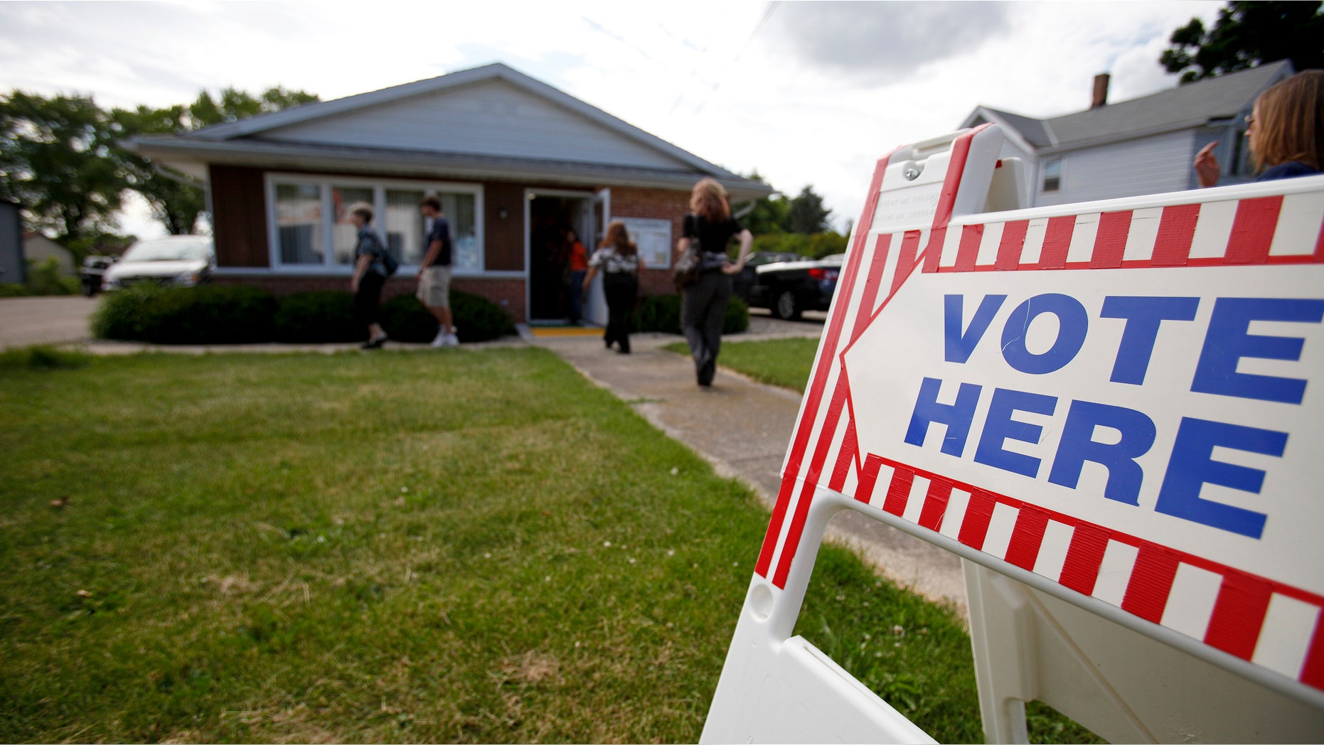 LAKE MILLS, WI - JUNE 5: Voters walk in and leave the Lake Mills Town Hall to cast their ballot in a recall election June 5, 2012 in Lake Mills, Wisconsin. Milwaukee Mayor Tom Barrett, a Democrat, is trying to unseat Republican Governor Scott Walker in the recall election. Opponents of Walker forced a recall election after the governor pushed to change the collective bargaining process for public employees in the state. (Photo by Andy Manis/Getty Images)