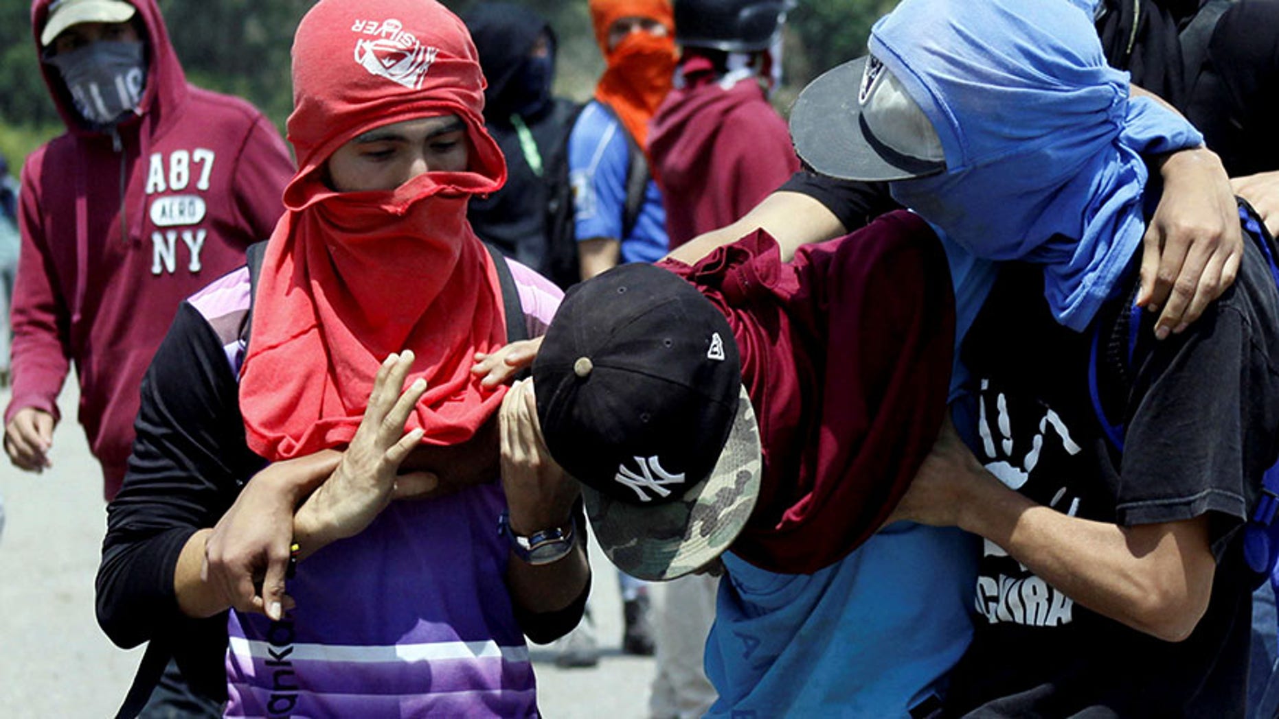 Demonstrators attend to a fellow protester during a protest against Venezuela's government in San Cristobal, Venezuela, April 6, 2017.