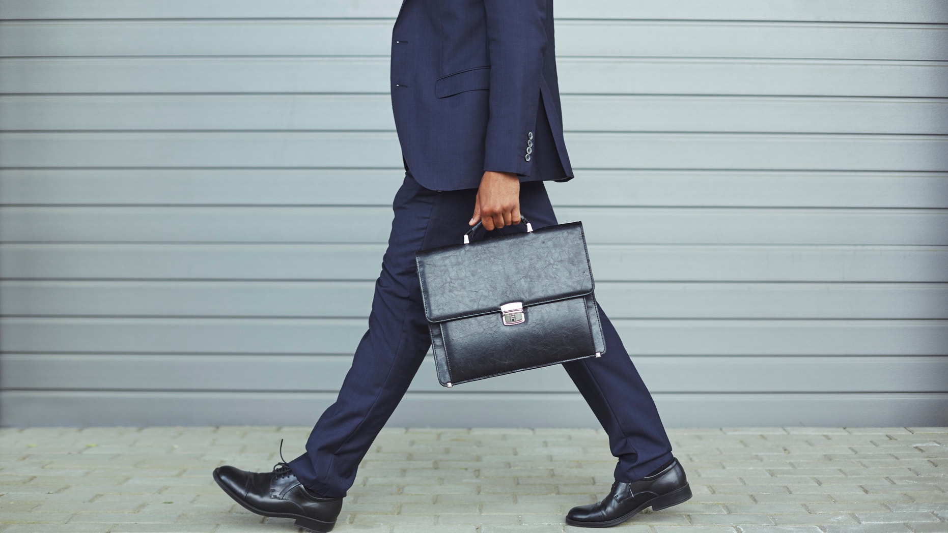 Legs of businessman in suit walking to work in the morning