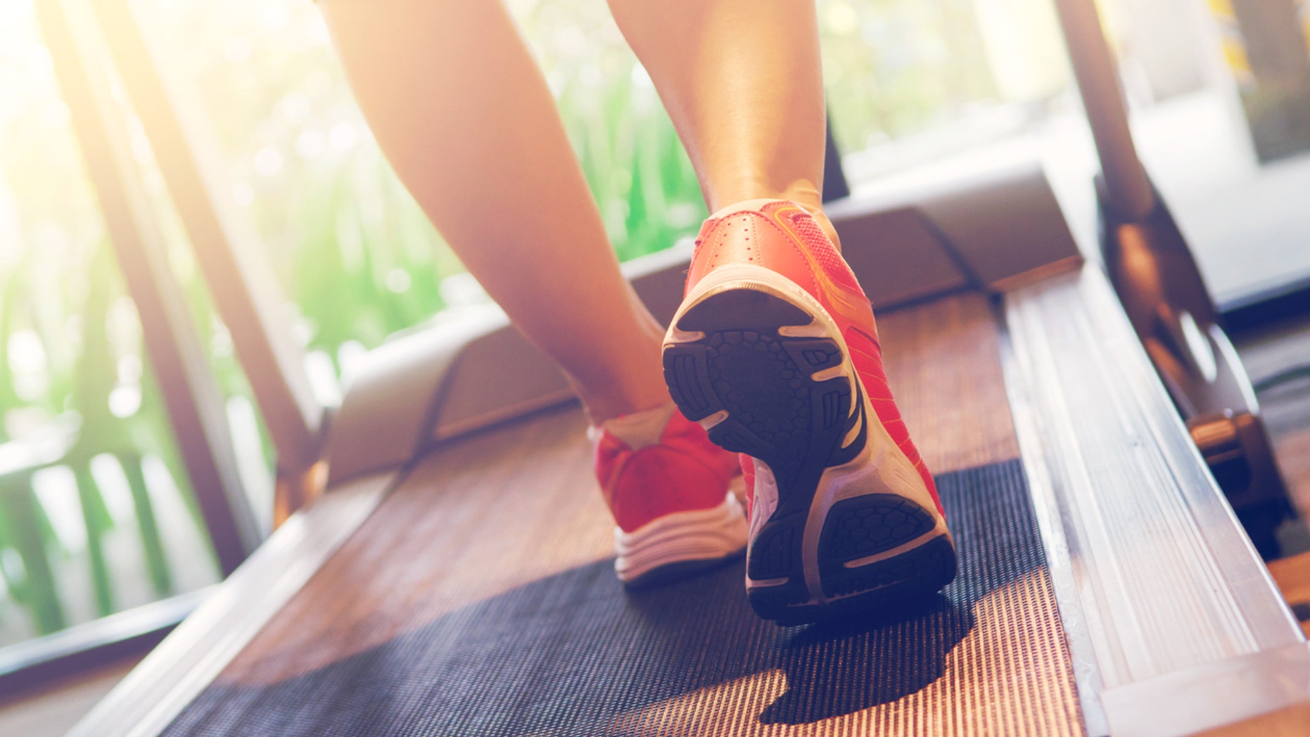 Close up on shoe athlete, Woman running in a gym on a treadmill concept for exercising and sunlight effect, fitness and healthy lifestyle