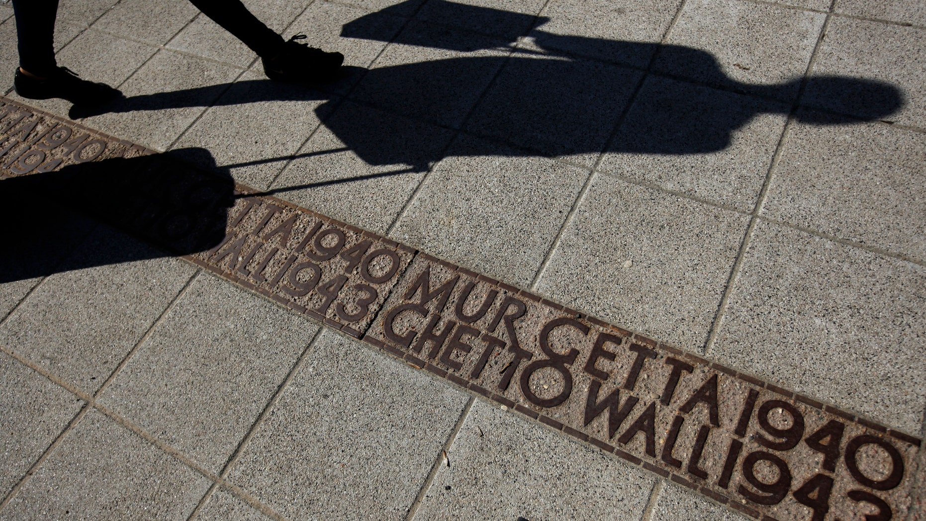 File photo - A woman walks over the line marking the boundaries of the Warsaw Ghetto in the centre of Warsaw April 16, 2013. (REUTERS/Kacper Pempel)