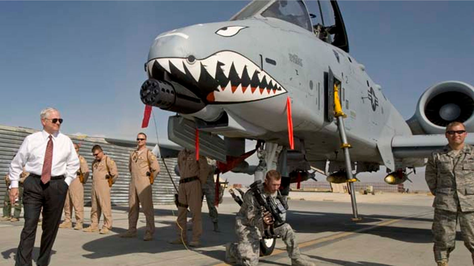 FILE 2008: Then-US Secretary of Defense Robert Gates, left, greets the crew and looks over an A-10 "Warthog," a close support aircraft, during an unannounced visit to Bagram Airfield.