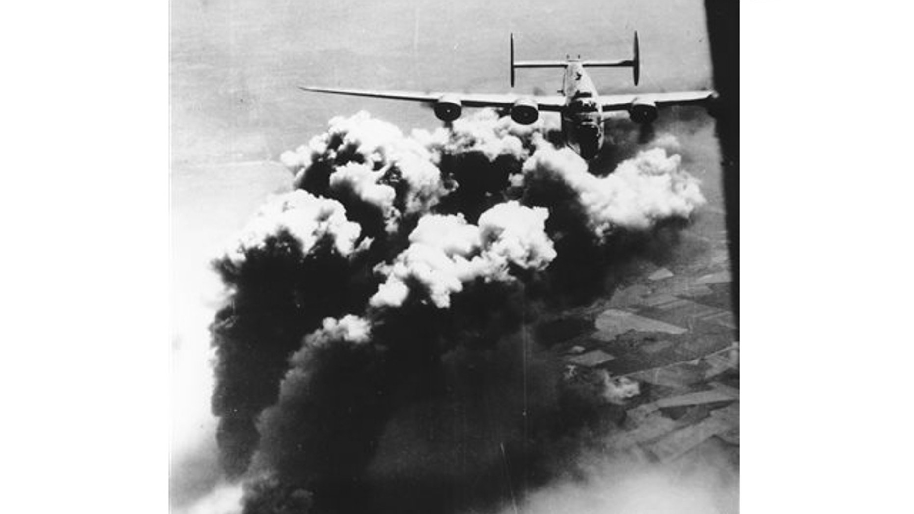 Aug. 1, 1943: A U.S. Army Air Force B-24 Liberator flies with plumes of black smoke rising from bombed facilities of the Astro Romano oil refinery at Ploiesti, Romania.