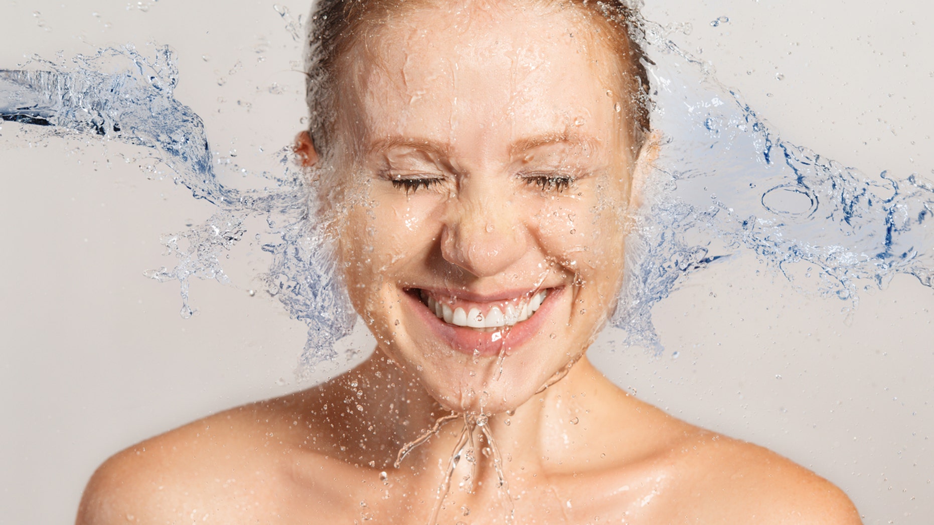 Happy beauty woman skin care, washing with splashes and drops of water