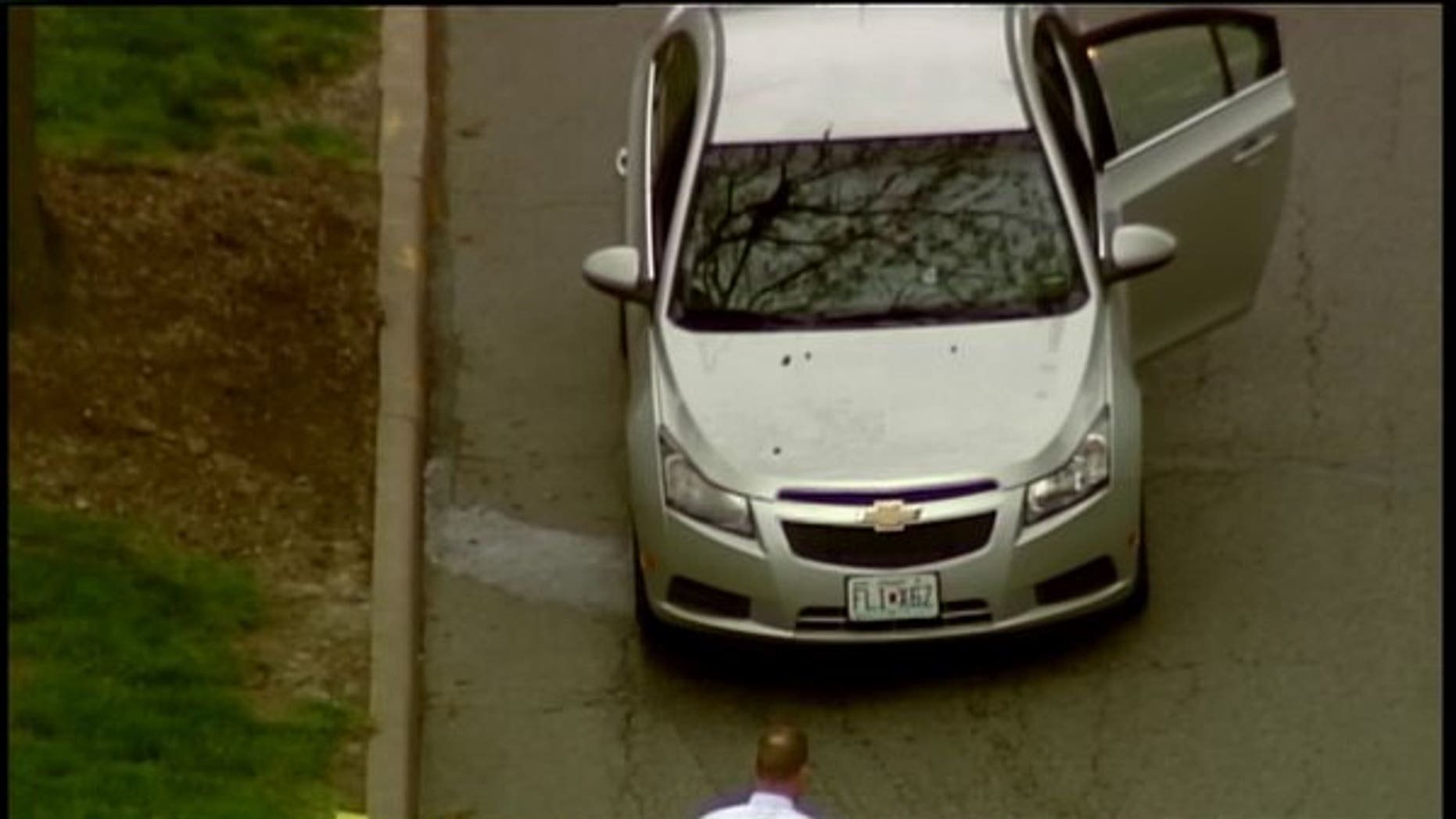Police investigating a car with apparent bullet holes on campus.
