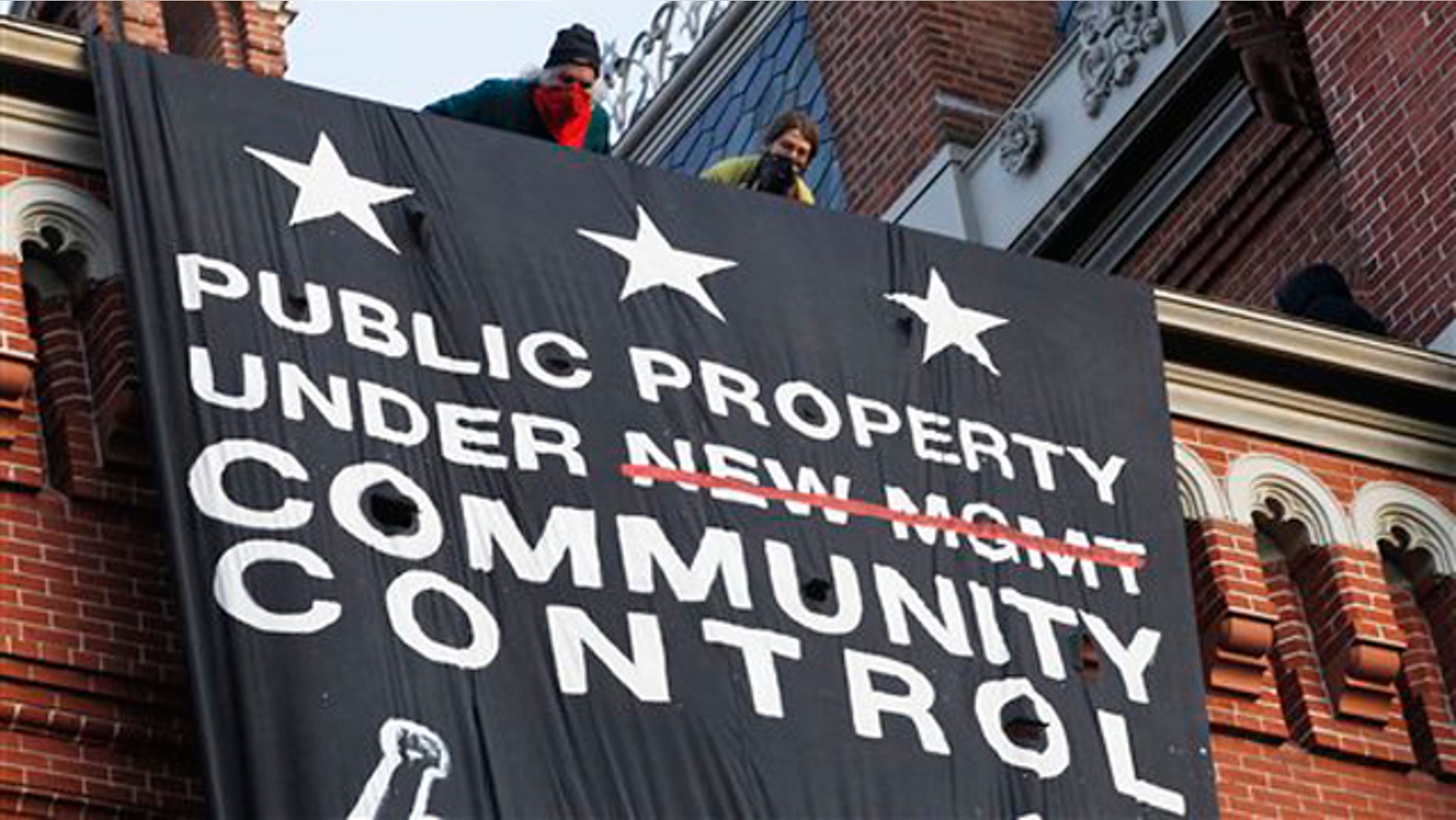 Nov. 19, 2011: A group of protesters inspired by Occupy D.C. protests look out from the roof, after hanging a banner on Franklin School building in Washington, D.C.