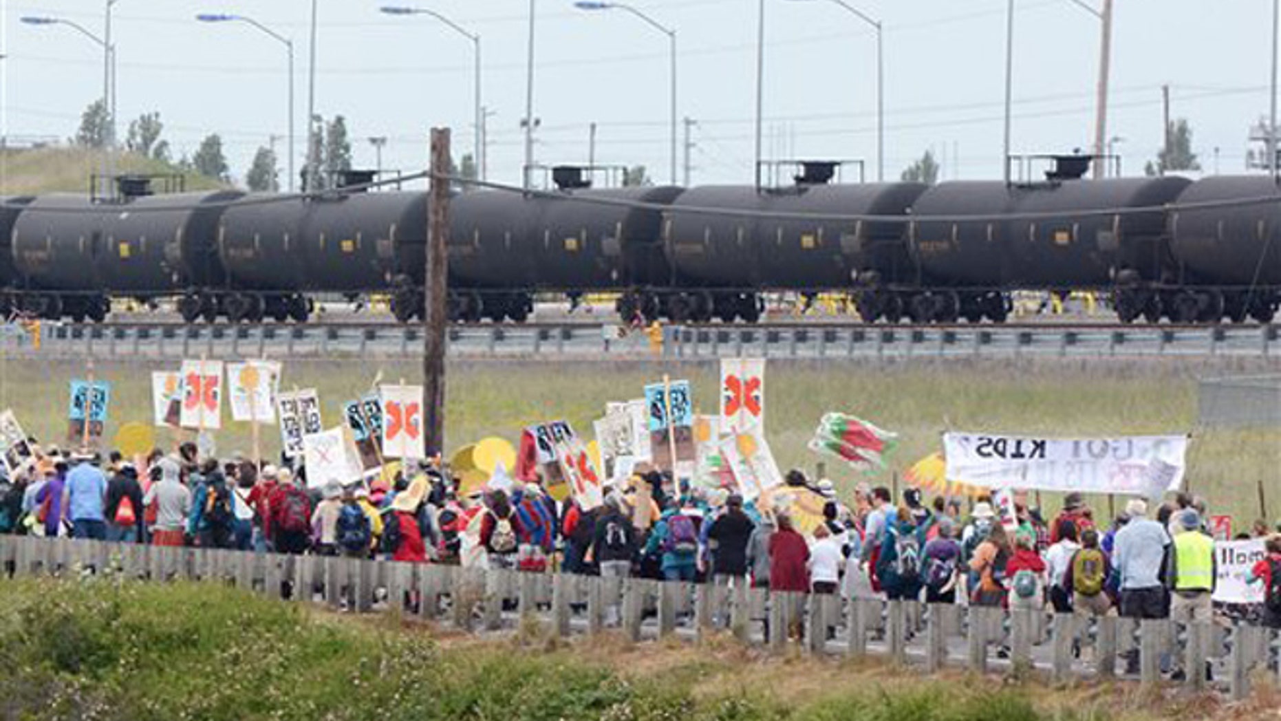 Anti-oil protestors walk past the Tesoro refinery rail yard in Anacortes, Wash., on Saturday, May 14, 2016. The protests are part of a series of global actions calling on people to "break free" from dependence on fossil fuels. (Scott Terrell/Skagit Valley Herald via AP)