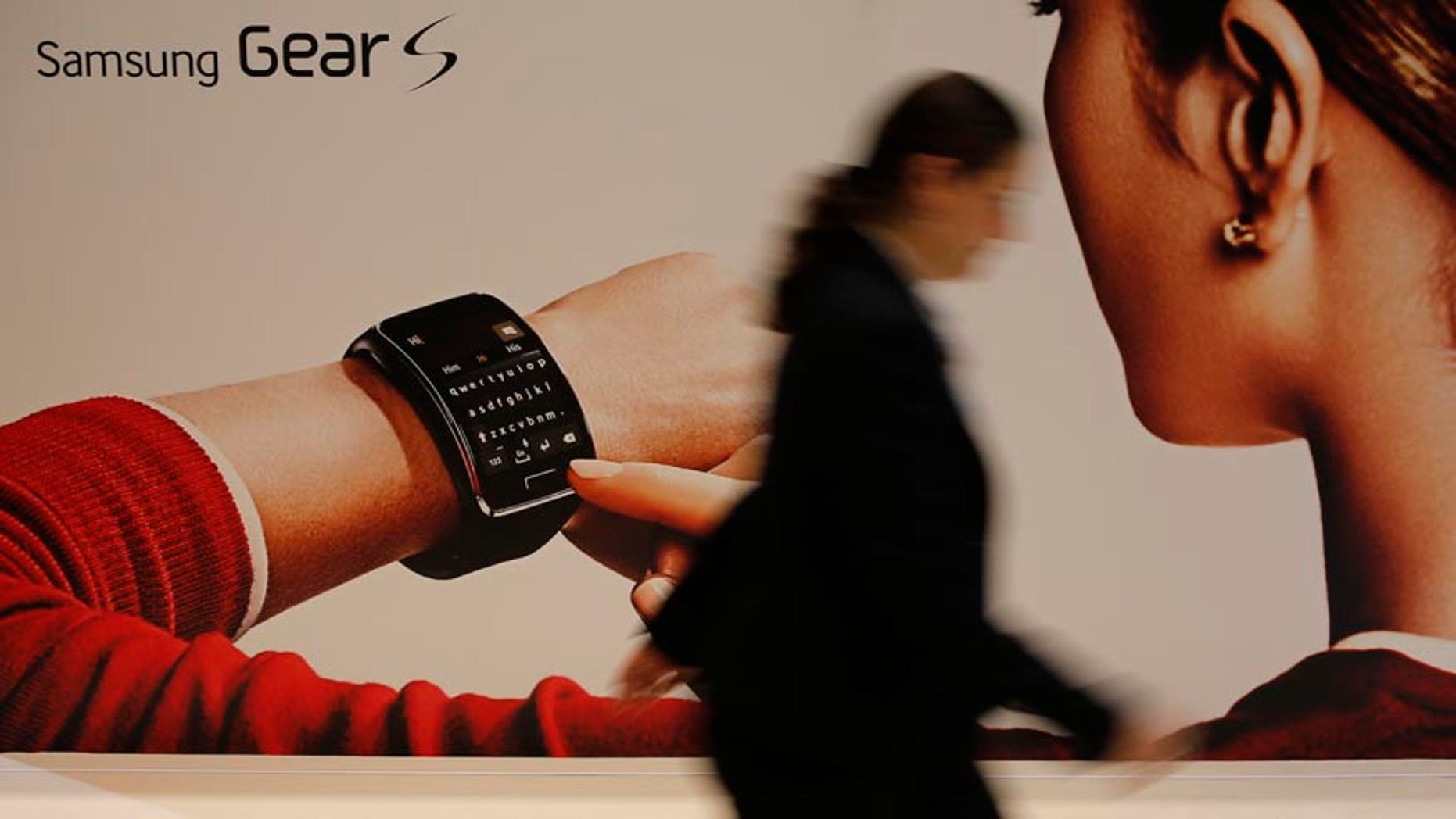 File photo. A visitor walks past a billboard advertising Samsung Gear S smartwatch at the IFA consumer technology fair in Berlin, September 5, 2014.