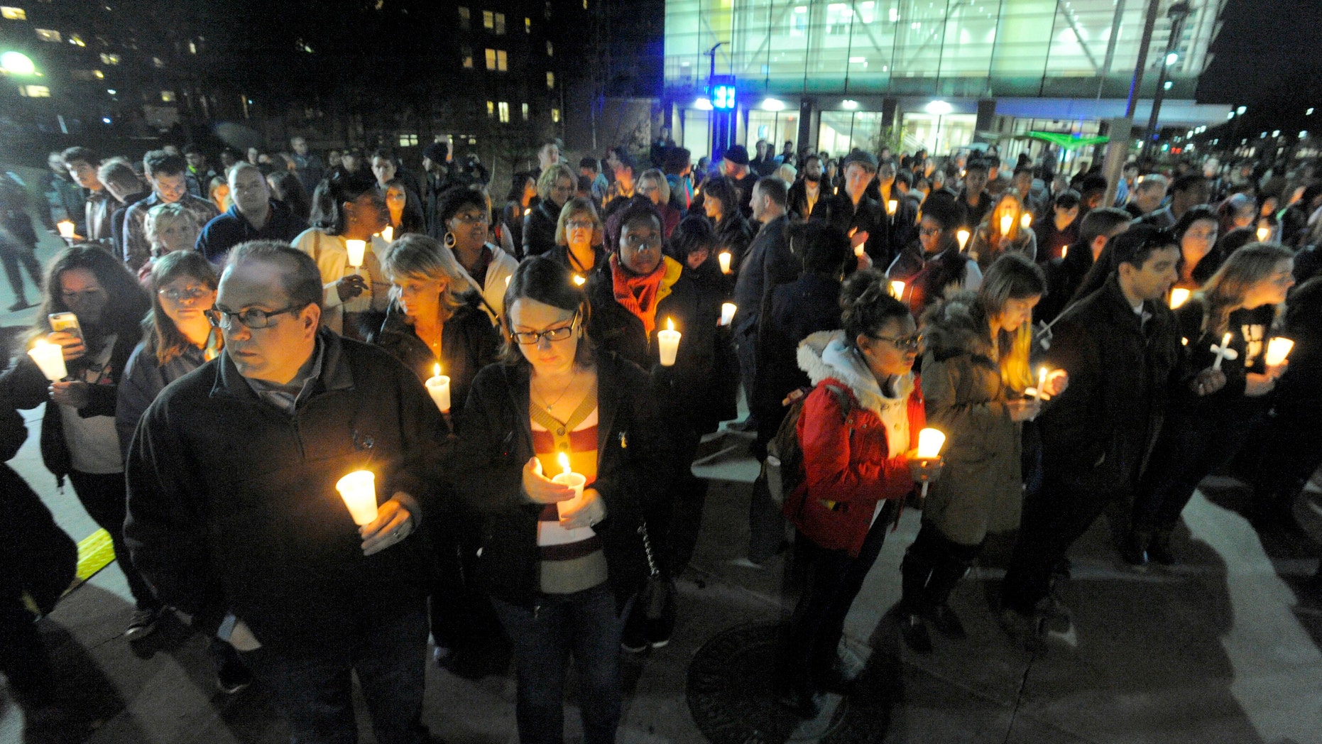 A large group gathers during a candlelight vigil on the campus of Wayne State University for Wayne State University campus police officer Collin Rose, Tuesday, Nov. 29, 2016, in Detroit. Rose was shot as he tried to arrest DeAngelo Davis, who was arraigned Friday on murder and gun charges. Rose died last Wednesday at a hospital. (Steve Perez/Detroit News via AP)