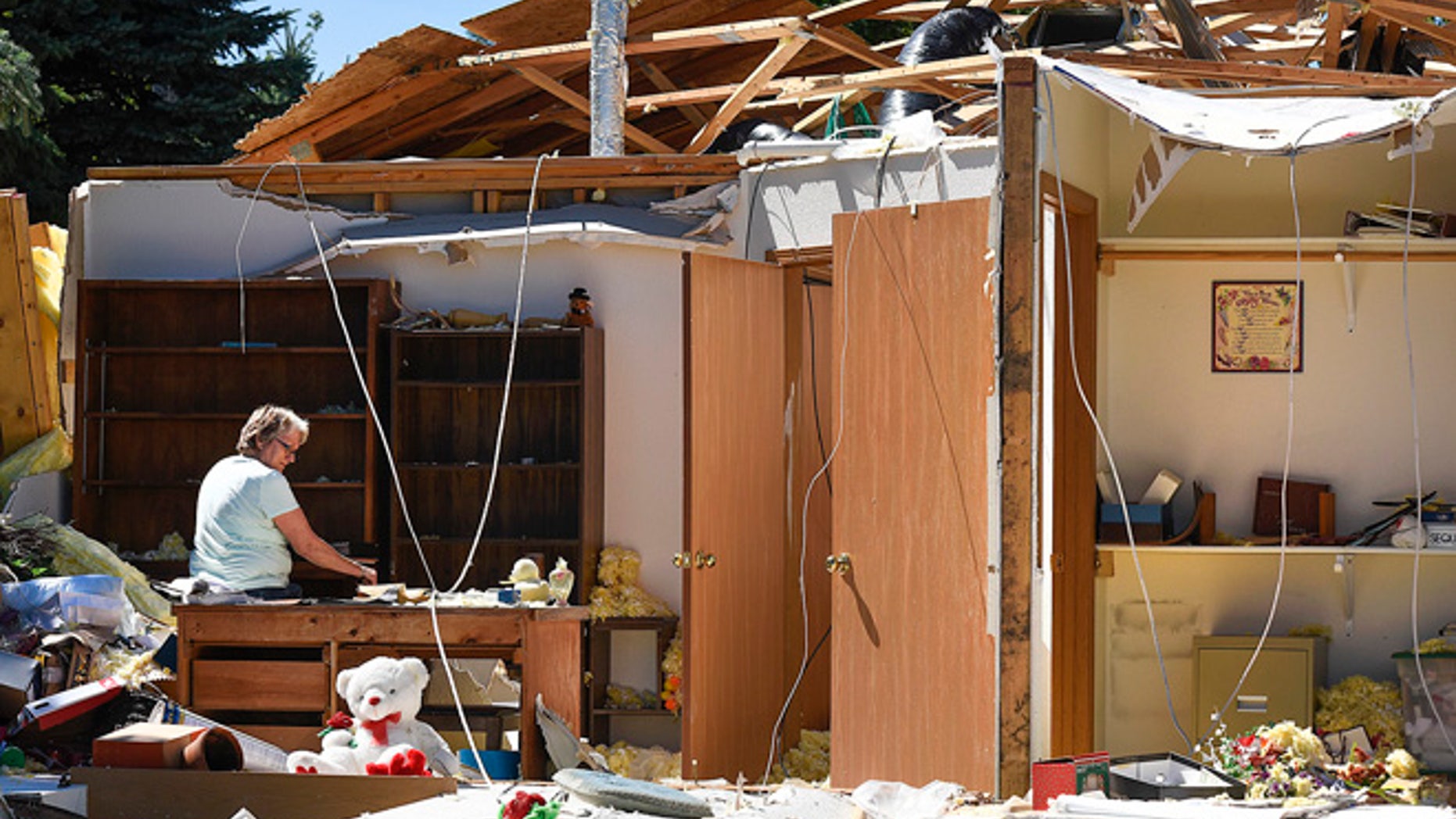 Marilyn Kuechle takes a break while packing the belongings in what's left of her sisters home Tuesday, July 12, 2016, after a tornado destroyed the home Monday night in Watkins. (Jason Wachter/St. Cloud Times via AP)