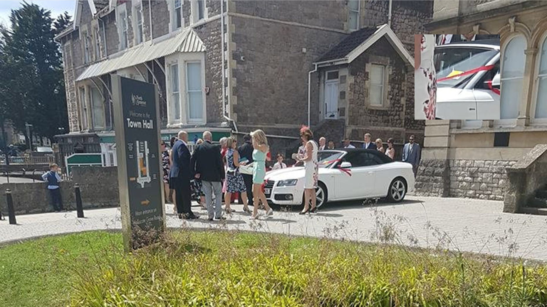 These images appear to show a happy couple being given a parking ticket on their wedding day - but it was placed on the windscreen as a prank. See SWNS story SWWEDDING; The white Audi convertible parked outside the registry office in Weston-Super-Mare, North Somerset, has what looked like a bright yellow parking ticket on the windscreen. Guests could be seen mingling around outside the town hall dressed in smart clothes. Freya Shepherd, who was passing by, spotted the suspected Penalty Charge Notice (PCN) and was shocked that a traffic warden could be so mean-spirited.