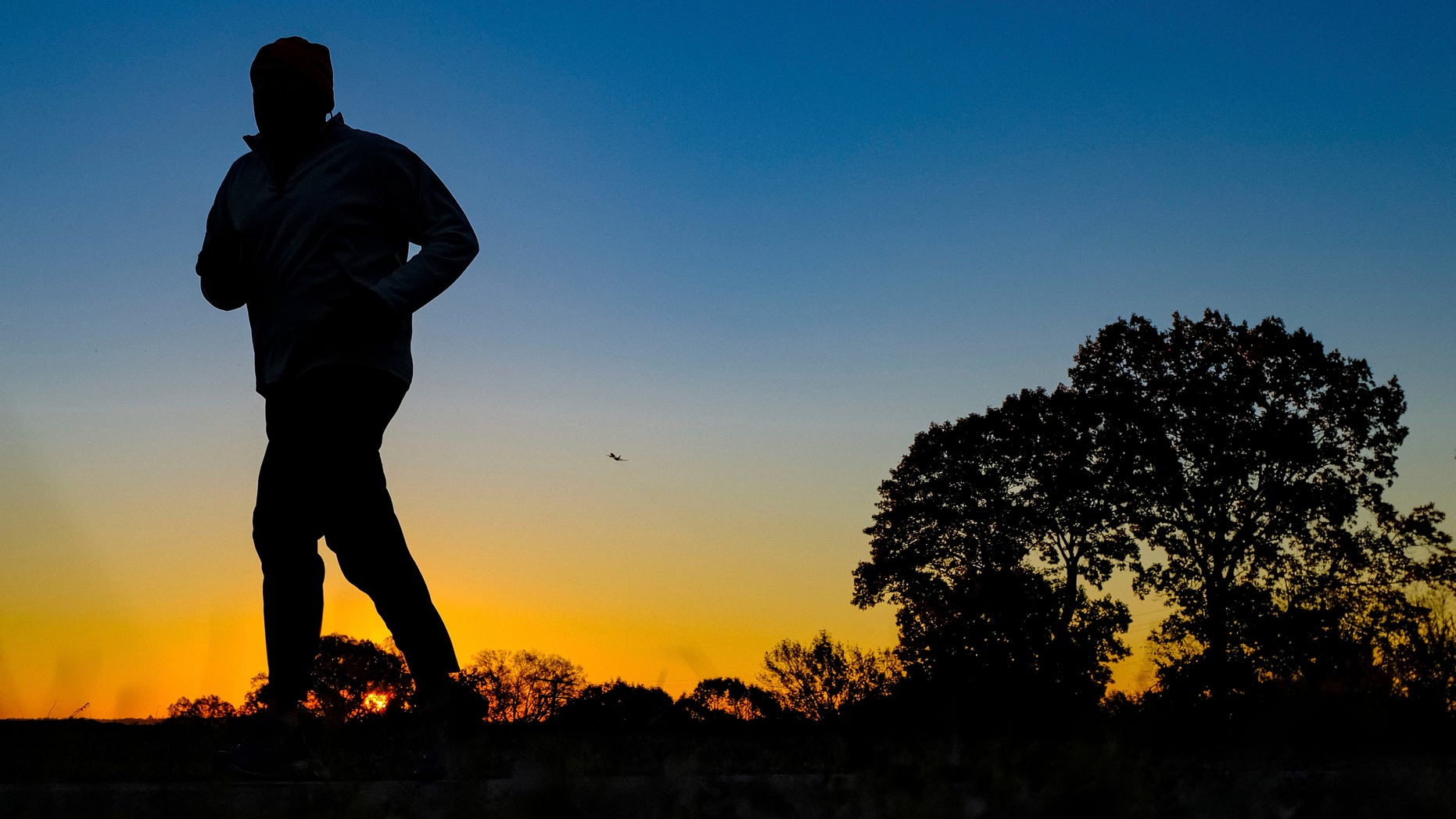 Nov. 22, 2016: In this file photo, a runner is silhouetted against the sunrise on his early morning workout near Arlington National Cemetery.
