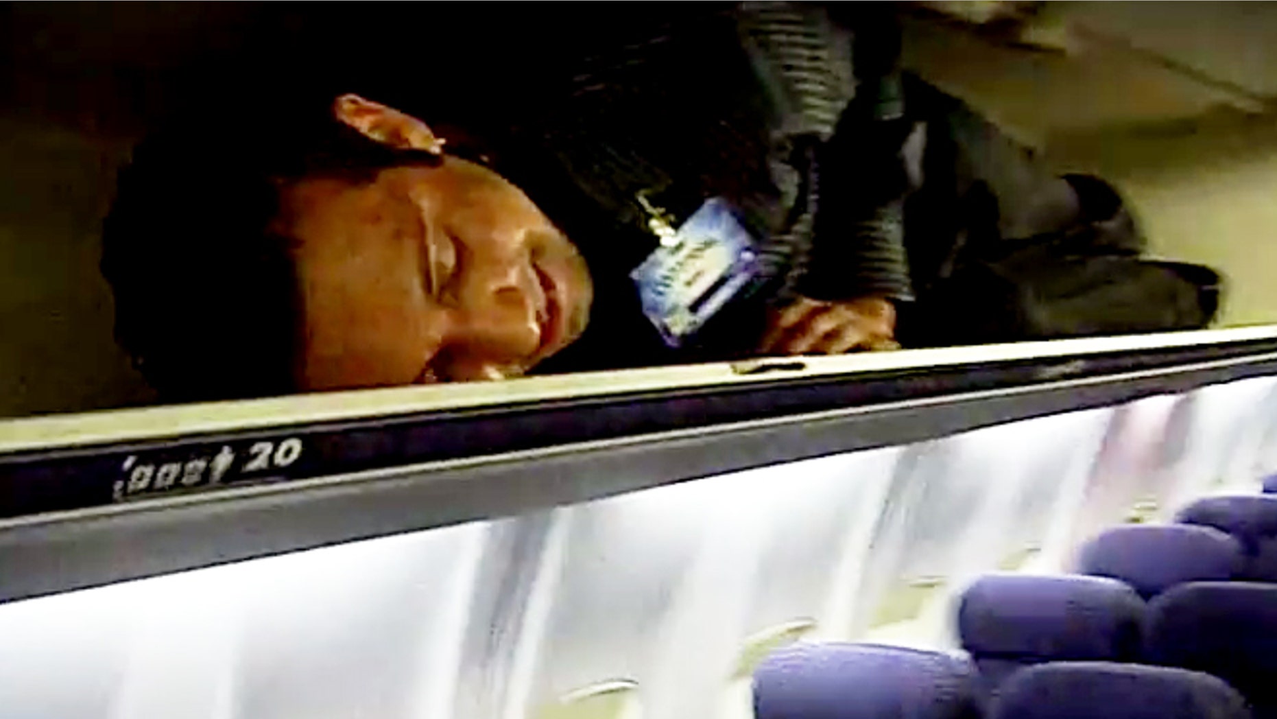 Crew members squeeze into overhead bins after passengers takeoff.