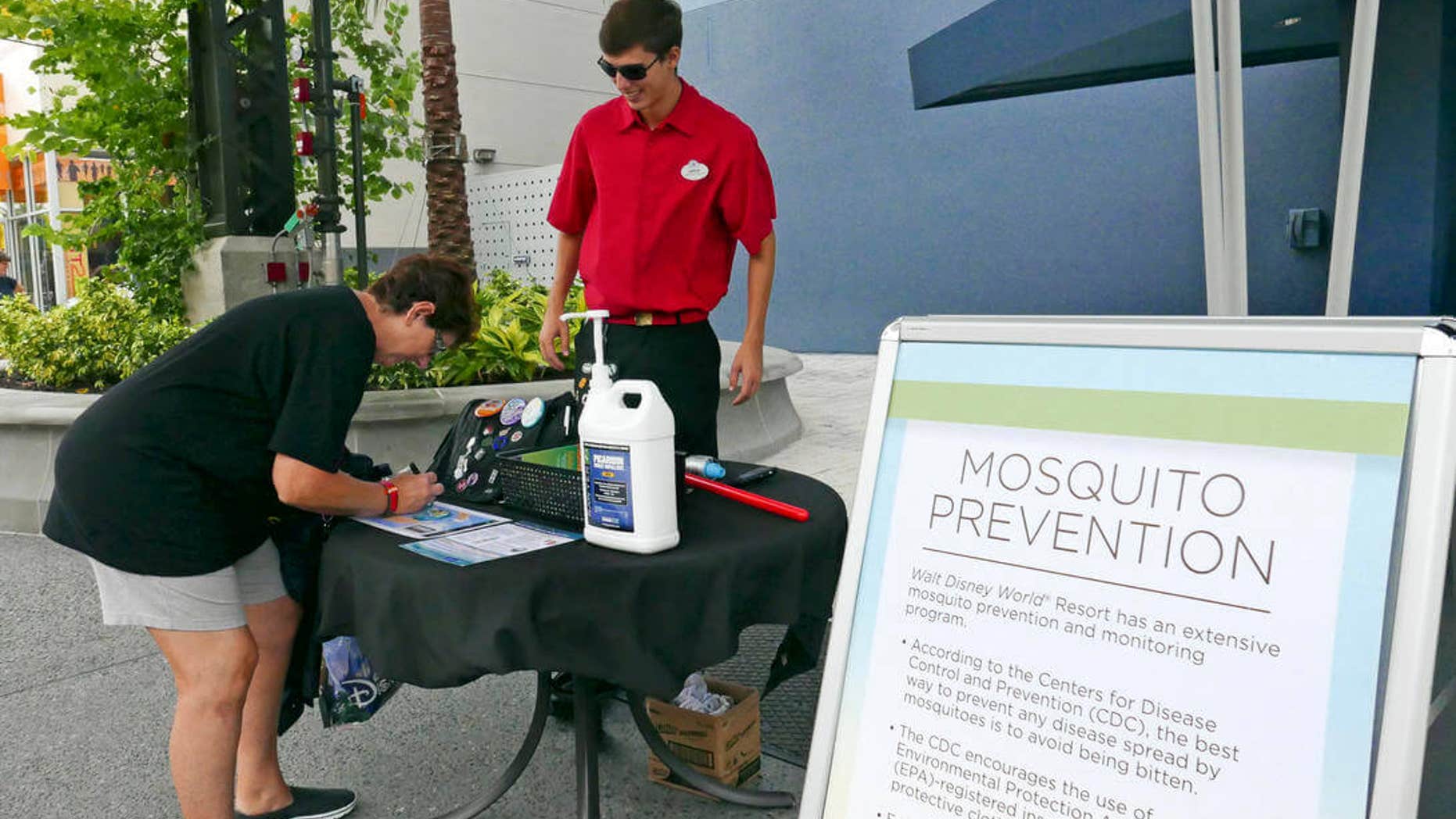 A tourist stops by a station giving out free mosquito repellant at Disney Springs in Lake Buena Vista, Fla. on Tuesday Sept. 13, 2016.