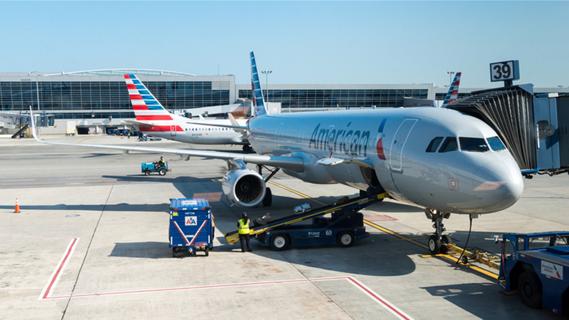 New York, USA - July 10, 2015: An America Airlines plane sitting at gate 39 at JFK airport late in the day as ground crew finish up before take off.