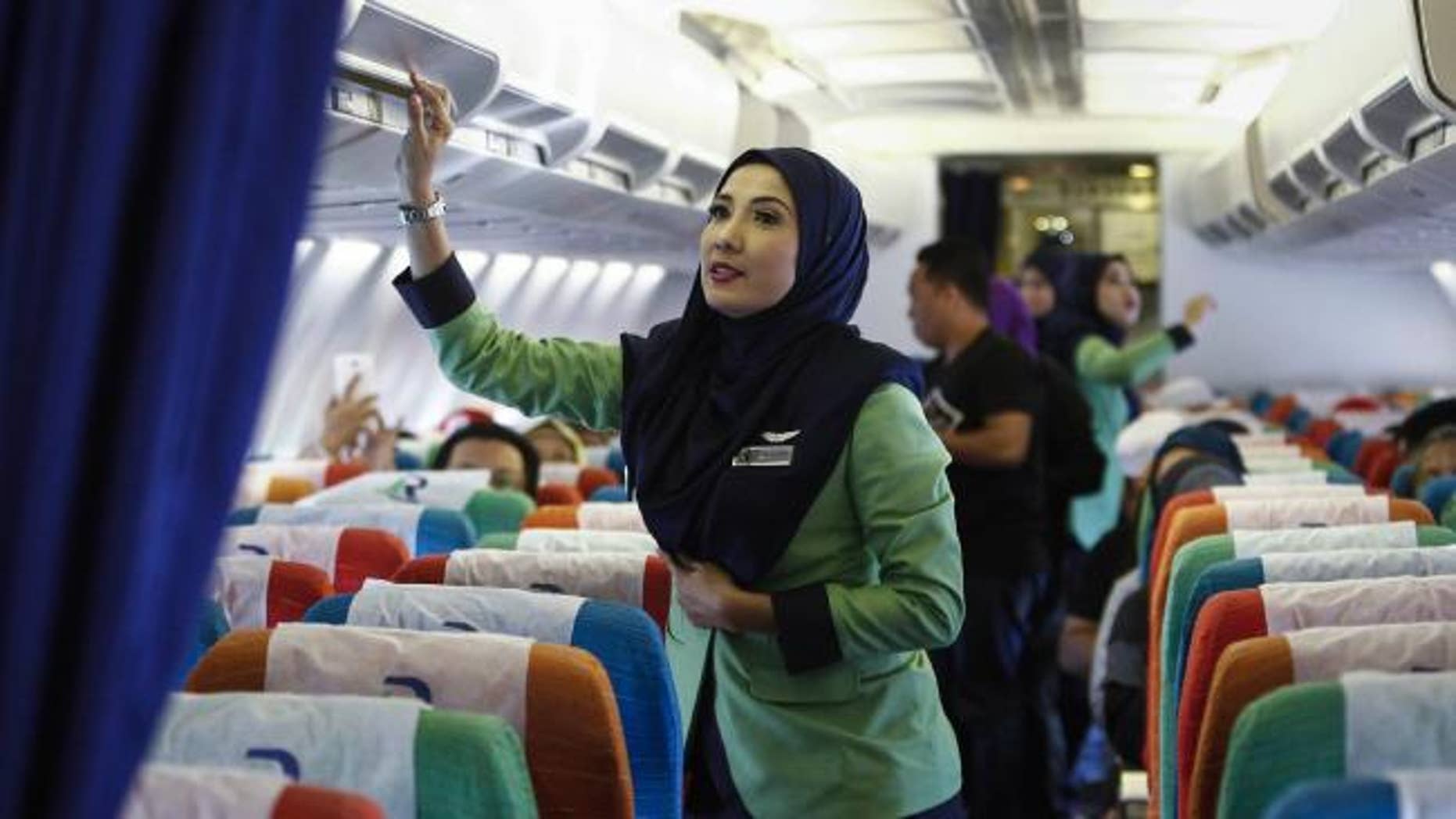 A stewardess for Rayani Air prepares the cabin for takeoff in this Dec. 22, 2015 file photo.
