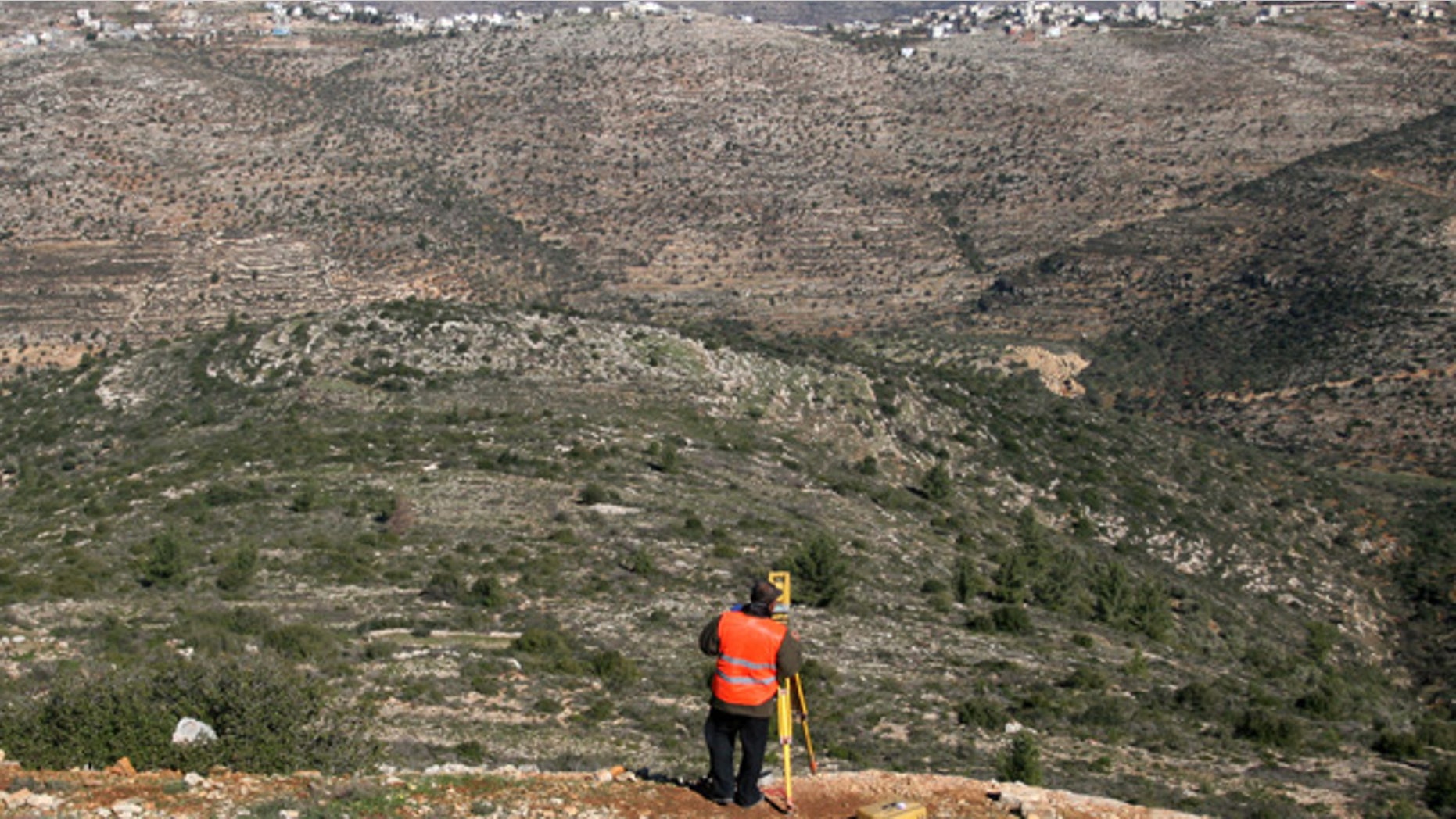 Jan. 6, 2010: A Palestinian surveyor works at the site where the first Palestinian planned city, Rawabi, will be build near the village of Atara, near the West Bank city of Ramallah. About 20 Israeli suppliers will help to build the first modern Palestinian city, but only after promising not to use products or services from Israeli settlements, the project's developer said Tuesday. (AP)