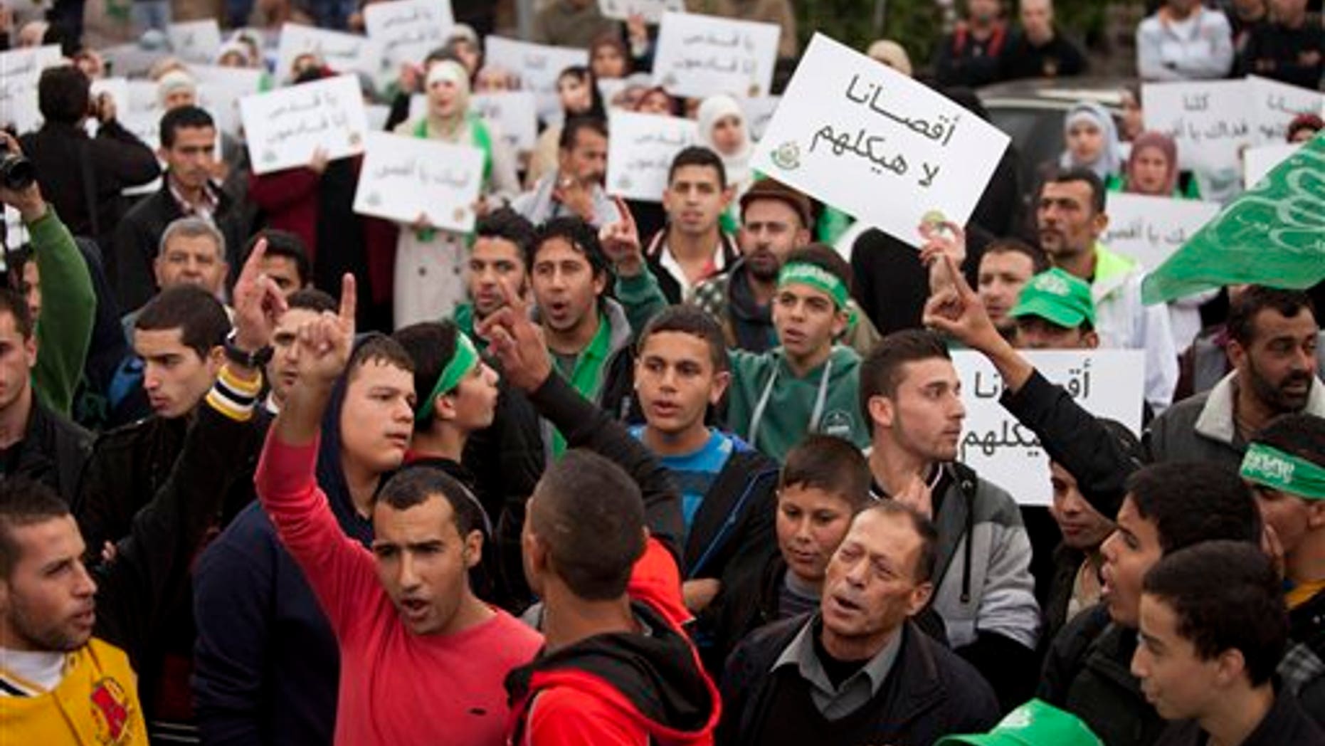 Oct. 17, 2014: Palestinian supporters of the Islamist movement Hamas shout slogans and hold pears with a slogan written in Arabic, "our Al-Aqsa is not their temple," during a protest against Israeli restrictions at the Al-Aqsa Mosque, in the West Bank City of Ramallah.