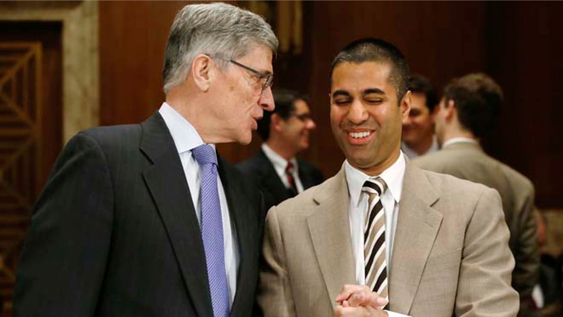 In this March 27, 2014 photo, Federal Communications Commission (FCC) Chairman Tom Wheeler, left, and FCC Commissioner Ajit Pai arrive to testify before a Senate subcommittee in Washington, D.C.