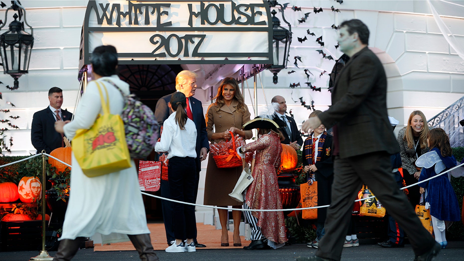 President Donald Trump and first lady Melania Trump hand out treats as they welcome children from the Washington area and children of military families to the White House.