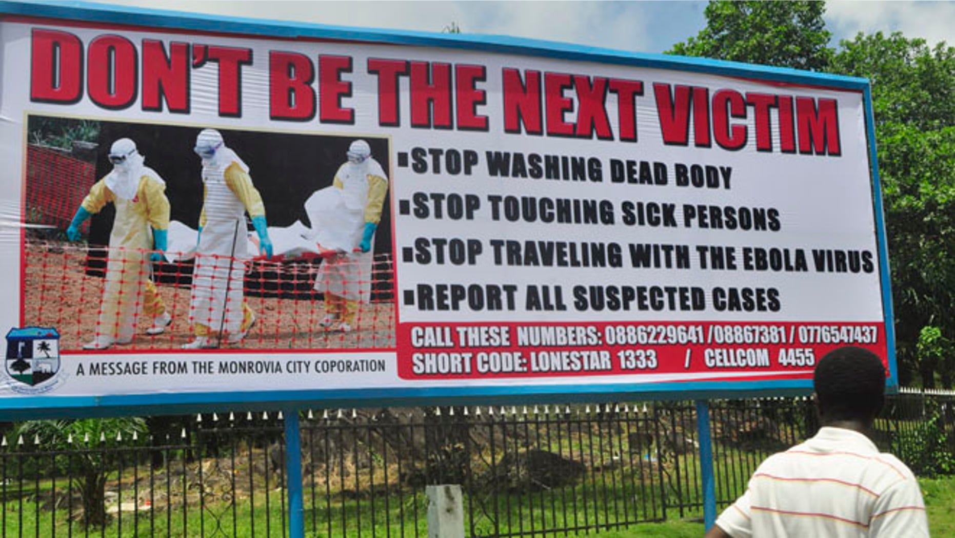 Oct. 10, 2014: A man walks past a billboard warning people of the deadly Ebola virus in Monrovia, Liberia