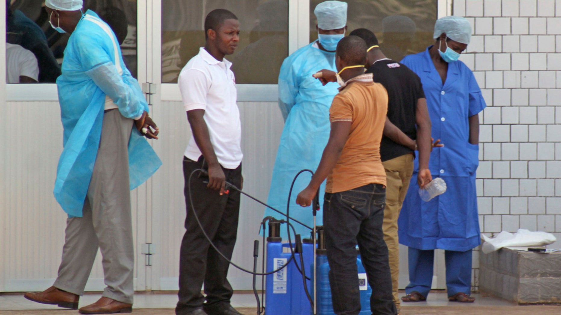 FILE - In this March 29, 2014, file photo, medical personnel at the emergency entrance of a hospital wait to receive suspected Ebola virus patients in Conakry, Guinea.